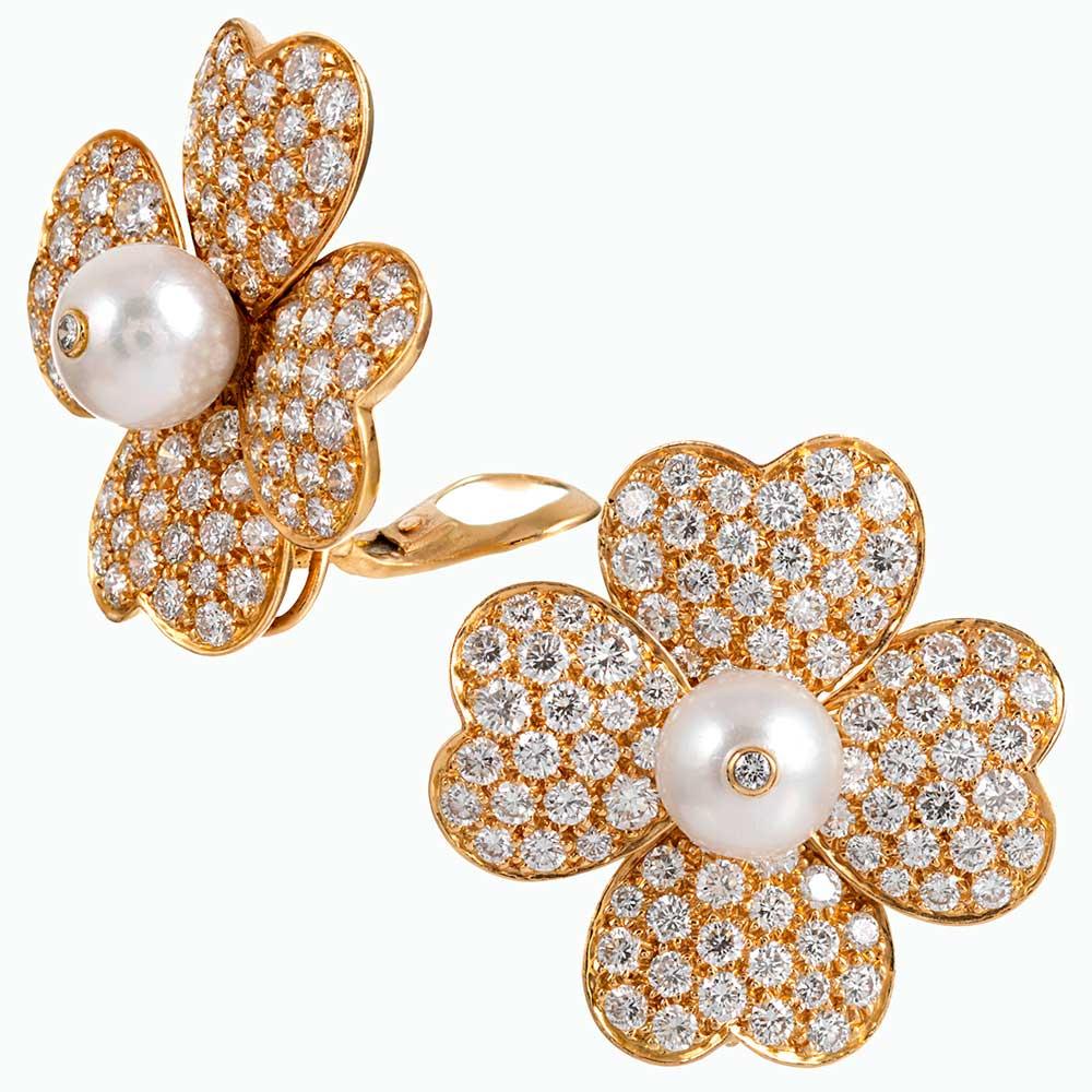 Heart-shaped petals of 18 karat yellow gold are embellished with brilliant white diamonds and fashioned into a flower, it’s center punctuated with a lustrous pearl and finished with a diamond solitaire. The esteemed house of Van Cleef & Arpels is