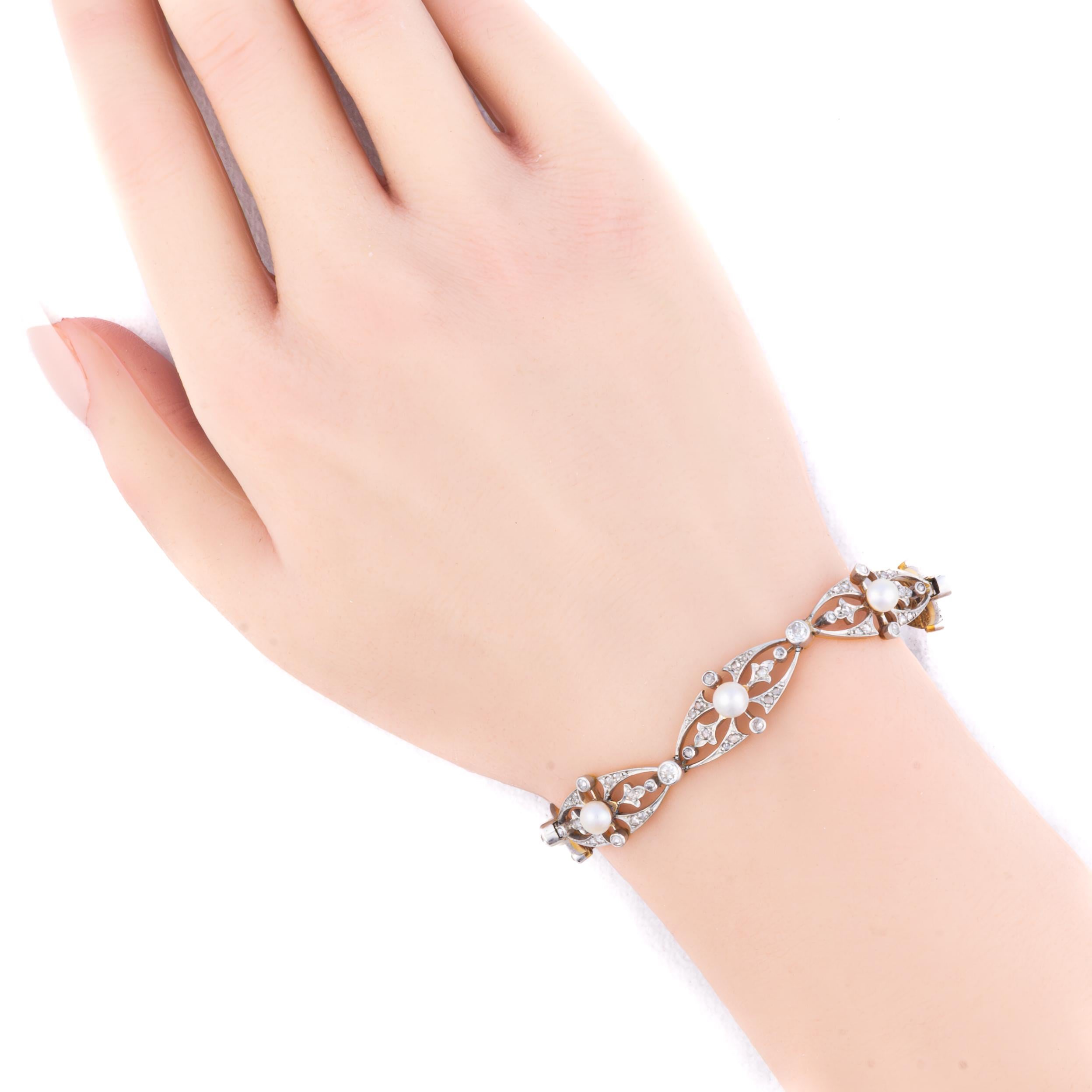 Diamond and Pearl Open Link Bracelet

An elegant bracelet composed of nine openwork marquise-shaped links, each delicately centered with a creamy natural pearl framed by rose cut diamonds. The intricately pierced design is crafted in silver over