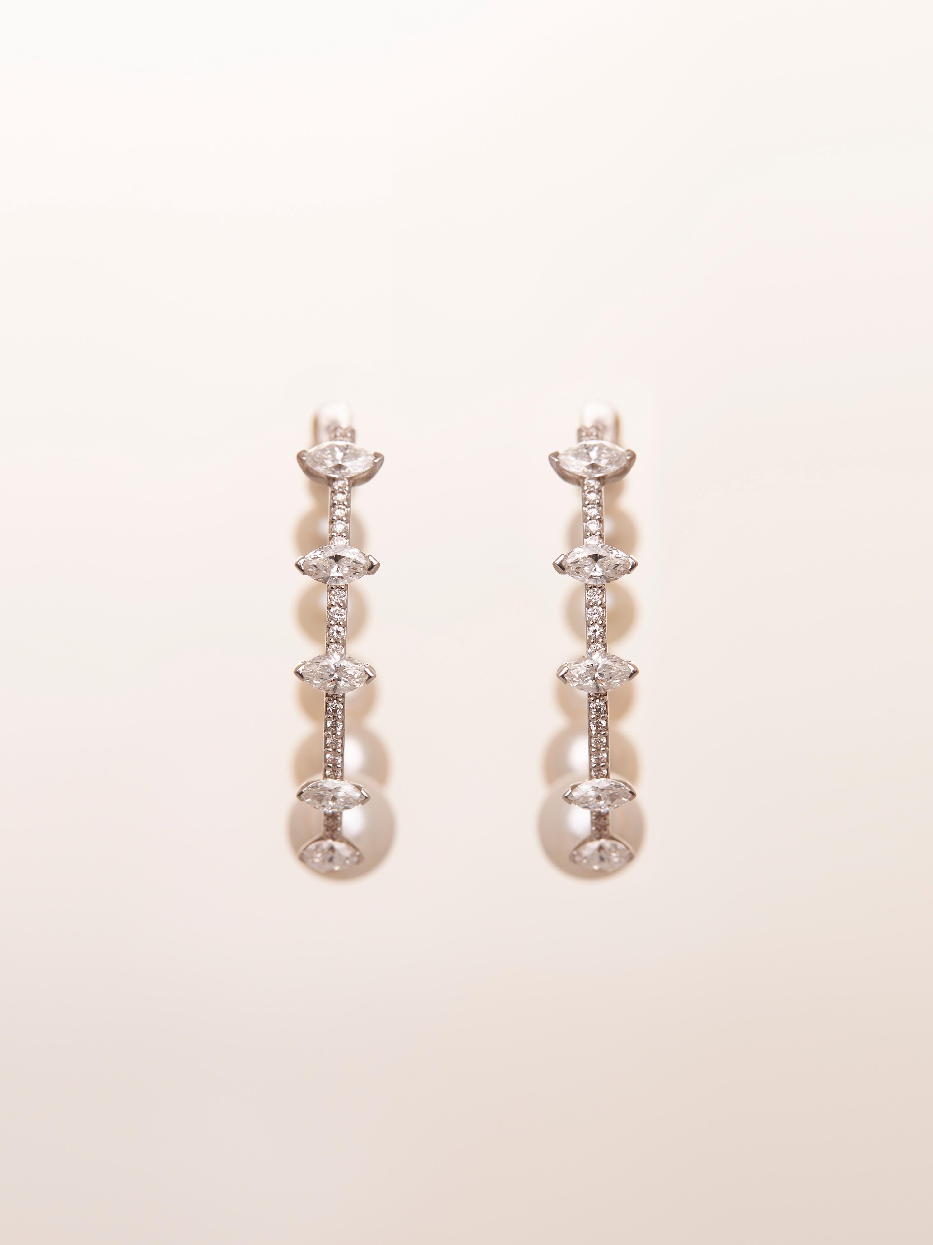 Questi eleganti cerchi con orbita di diamanti e perle sono una miscela magistrale di raffinatezza e stile. Realizzati con un delicato equilibrio di diamanti a taglio marquise e rotondo intervallati da perle lucenti, questi piccoli cerchi circondano
