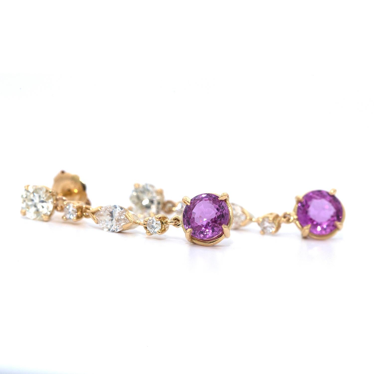 These Diamond and pink sapphire hanging earrings are set in 18k yellow gold and are anchored by a round brilliant cut clean white diamond at the top that weigh 0.40 cts and is connected by 3 diamonds, 2 round and 1 marquise shaped diamond, that hold