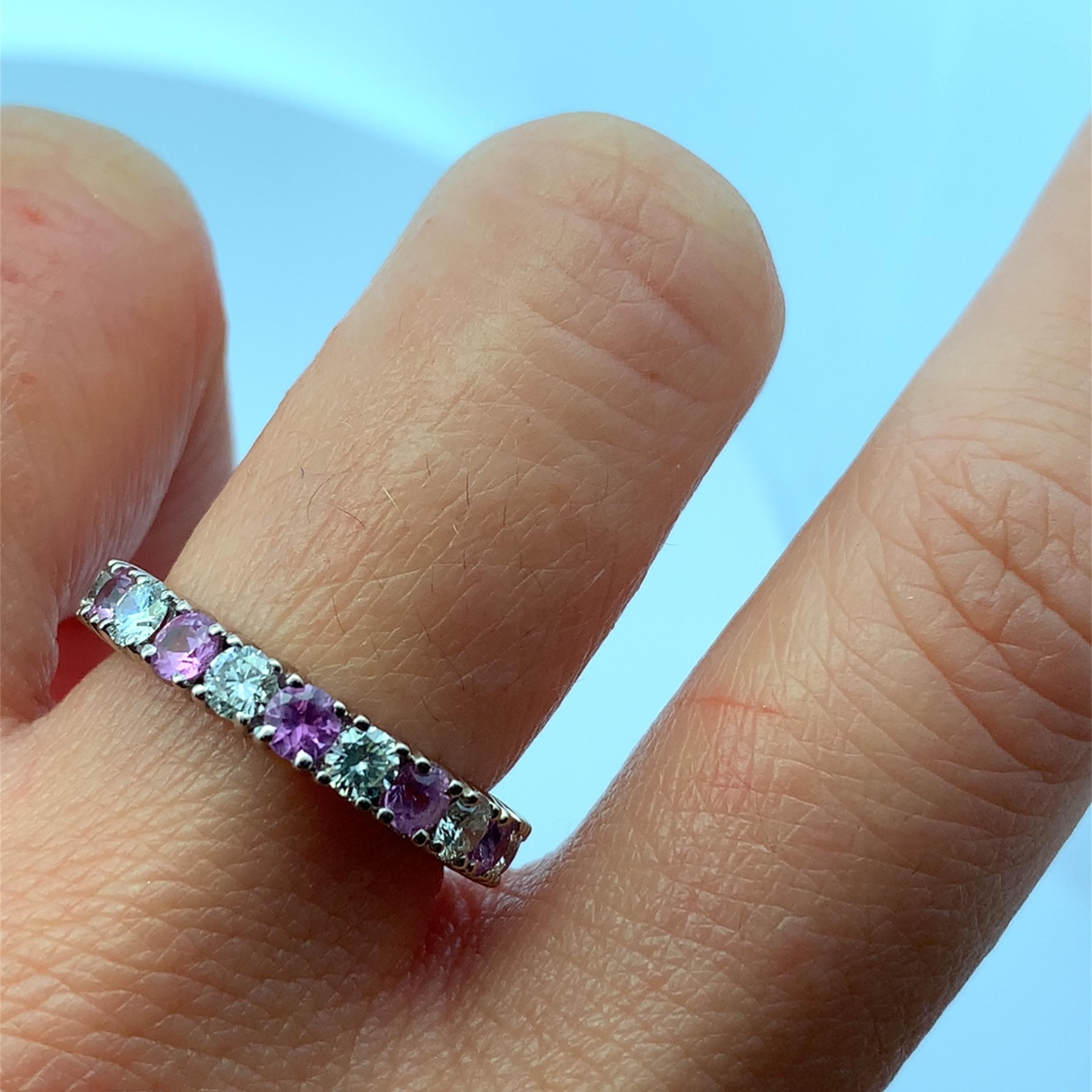 Si tratta di un elegante anello in oro bianco 18 ct. con un disegno a Eternità completa incastonato di diamanti e zaffiri rosa. L'anello è una misura K e mette in mostra una splendida combinazione tra la pietra principale di Zaffiro Rosa e le pietre