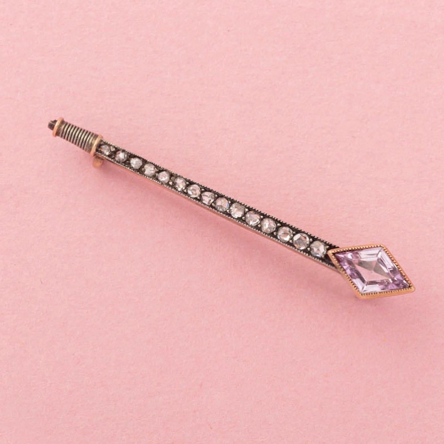 A rose and white gold nail pendant with a kite shaped synthetic pink sapphire, and with 15 old cut diamonds all mille griffe set at the end is a small curl, circa 1920.

weight: 3.10 gram
length: 5 cm
width: 0.7 cm