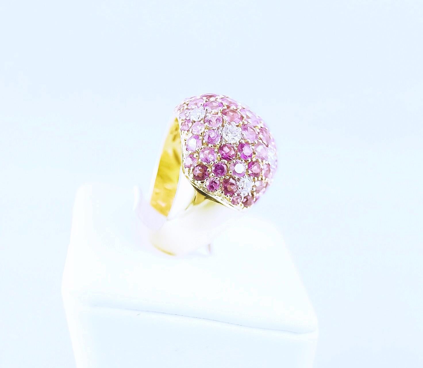 A stunningly designed ring made of 53 pink sapphires 5.31ct, 25 pink tourmalines 1.88ct and 9 diamonds 0.78ct mounted in 18K yellow gold. This feminine handcrafted jewel harmoniously combines a symphony of colors into a sparkling piece of art. This