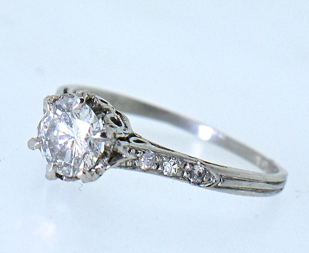 Diamond and platinum Edwardian ring centering an approximately .70 ct. fine white diamond, G/H in color (near colorless) and very slightly included (VS).  This diamond is accented on both sides by small white diamonds.  The six prong hand made,