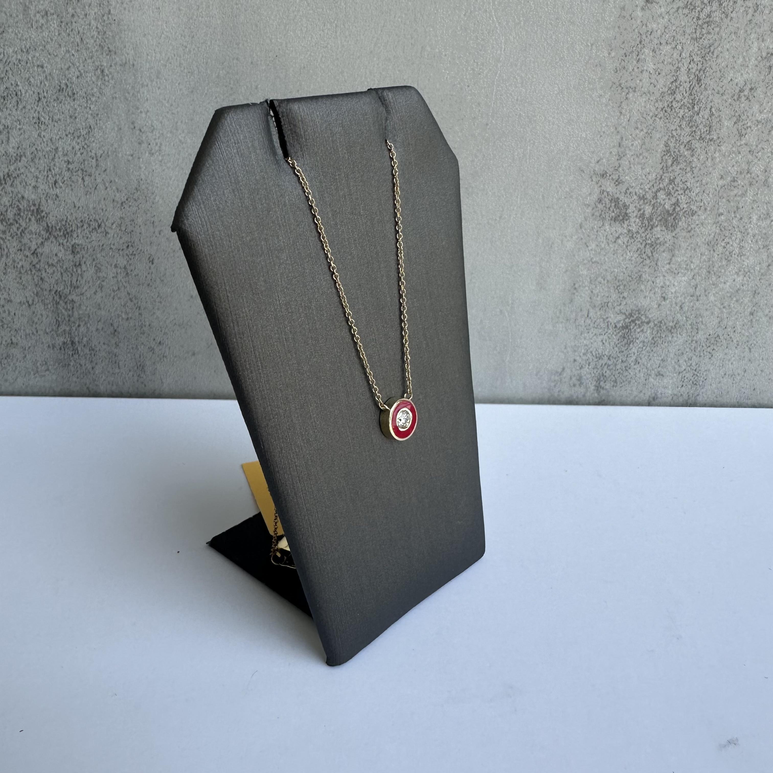 Aggiungi un tocco di colore ed eleganza alla tua collezione di gioielli con questa splendida collana con diamanti e smalto rosso in oro giallo 14 carati. Con un diamante rotondo di colore naturale GH e purezza SI2 del peso di 0,13 carati