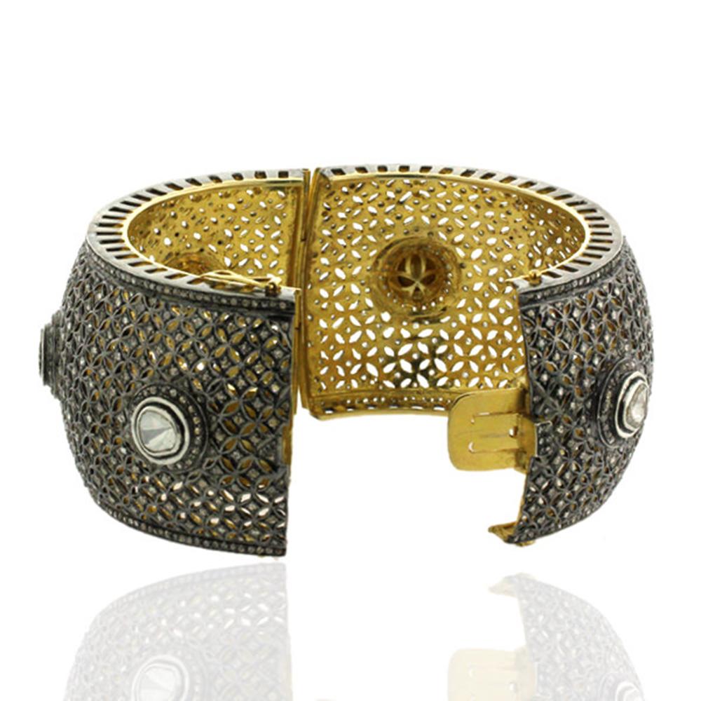 Beautiful Diamond and Rosecut Diamond Cuff Bangle in Gold and Silver with filigree design is a perfect designer cuff. This cuff opens on side with a side lock.

14kt gold: 9.18gms
Diamond: 12.47cts
Silver: 93.91cts
