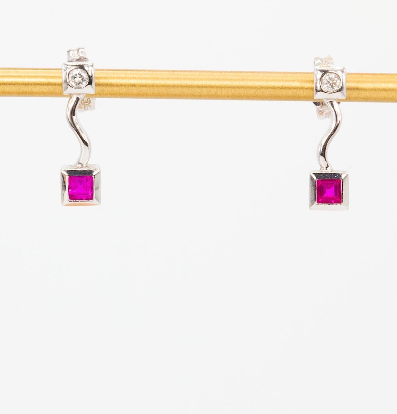 Diamond and Ruby 14K White Gold Dangle Earrings

Elegant and refined, these 14K white gold earrings showcase a classic pairing of vibrant rubies and sparkling diamonds. Each earring features a square cut natural ruby, totaling approximately 0.22