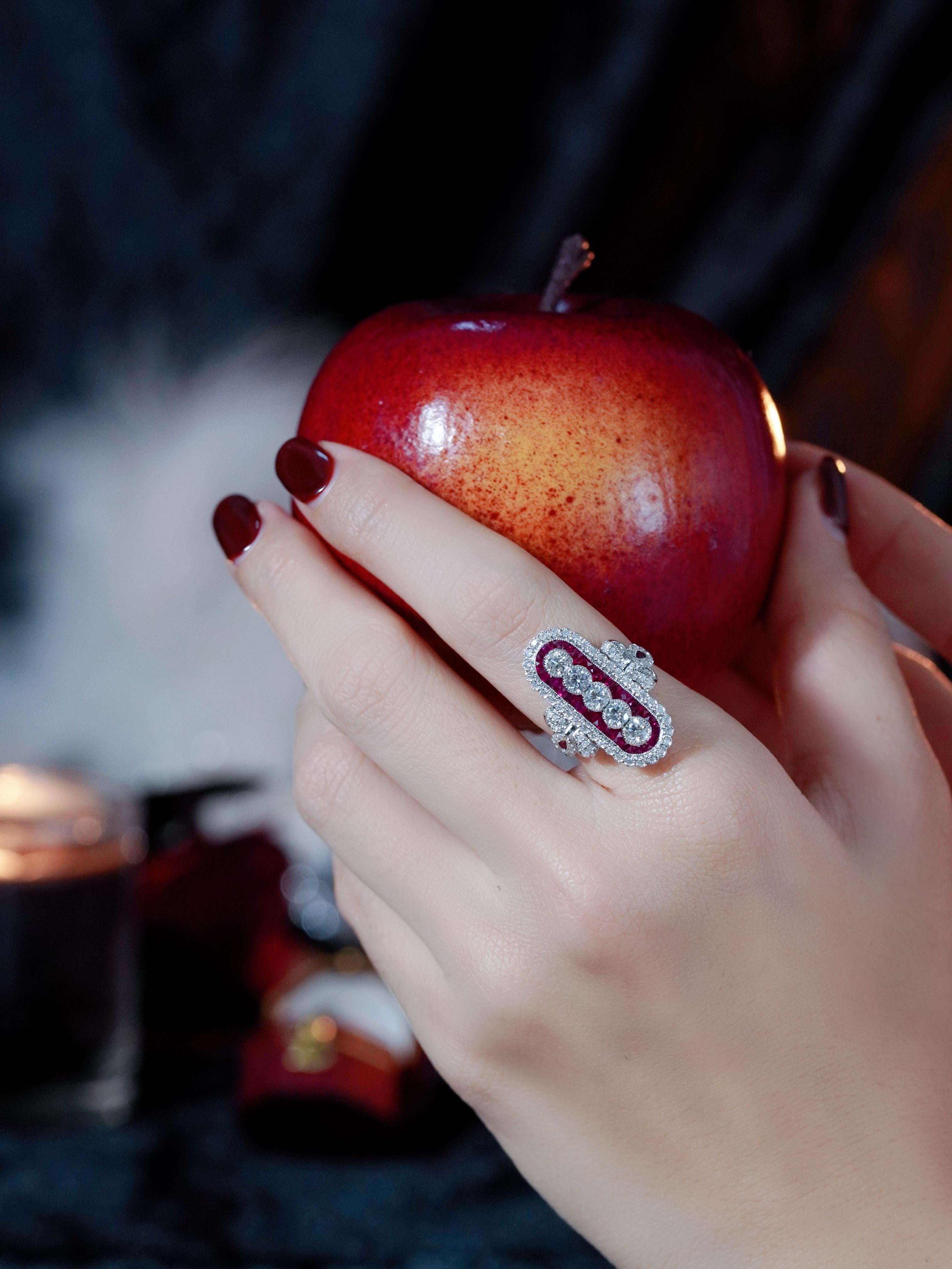 Le romantisme classique rencontre un design audacieux dans cette éblouissante bague de cocktail de style Art déco. Un diamant rond brillant se trouve au centre, serti verticalement pour une tournure unique, tandis que de vibrants rubis de taille