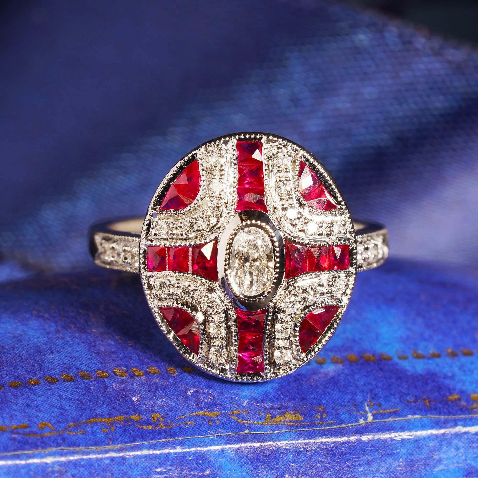 This is a lovely Art Deco style diamond and ruby 14k white gold ring. The ring is set with charming oval cut diamond that weights approximately 0.17 carat. The center stone is accentuated by gorgeous faceted French cut rubies and sparkling round cut