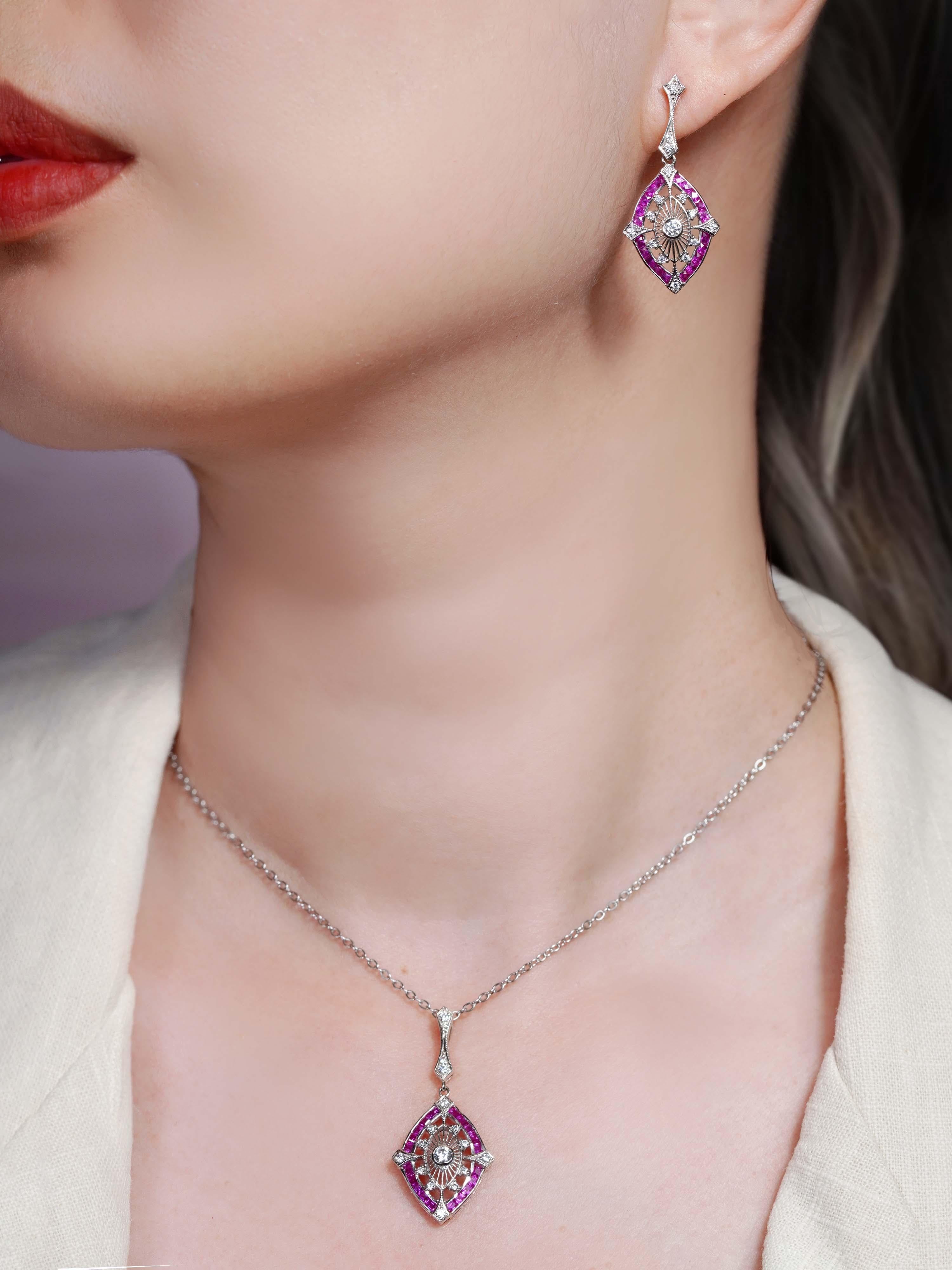 Célébrant l'élégance de l'Art déco, ce pendentif est orné d'un diamant rond en son centre, serti dans un motif d'inspiration florale. Le cadre extérieur en forme de marquise est orné de rubis français éclatants, créant un contraste saisissant et un