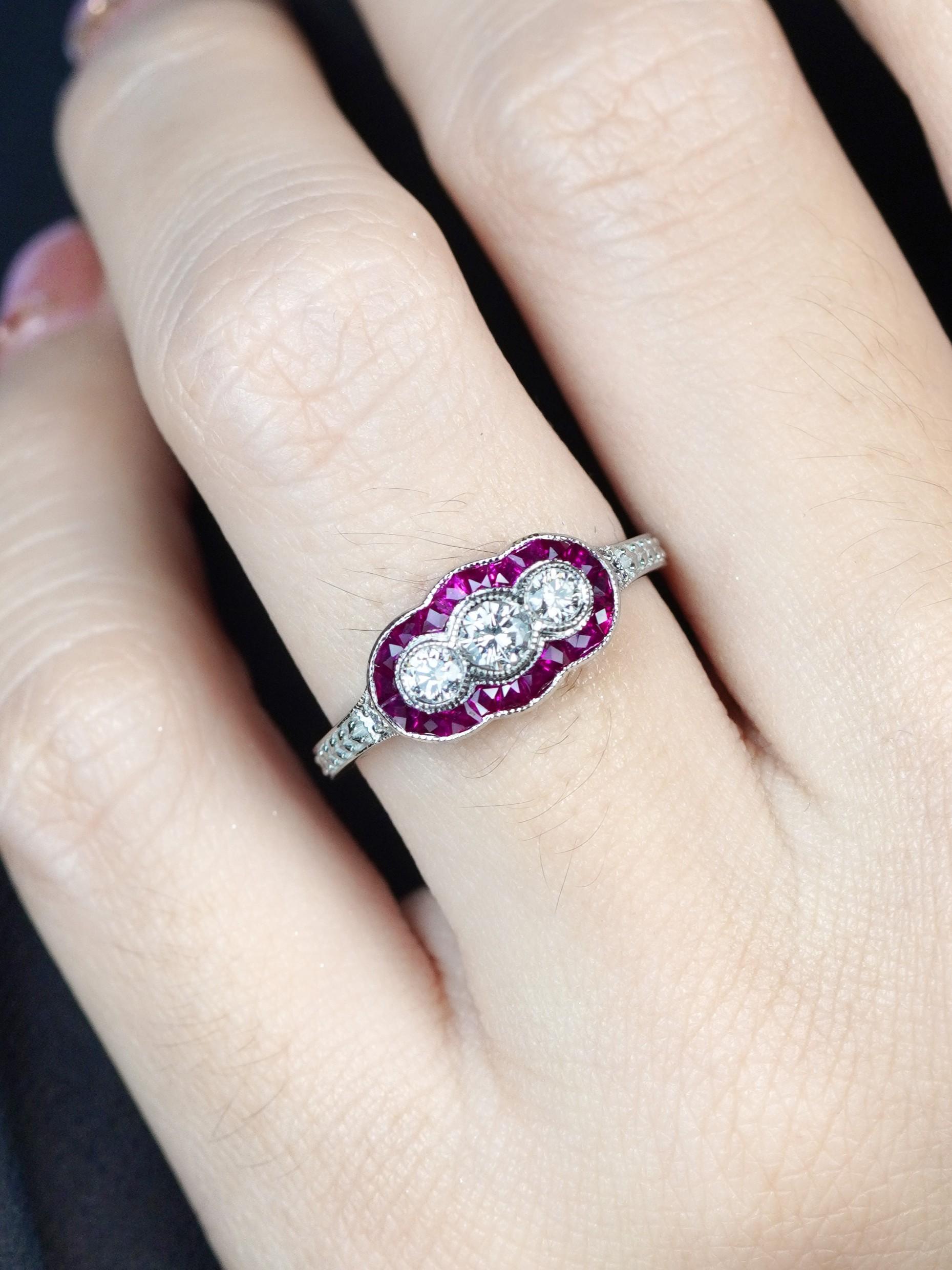 Pleine de charme vintage, cette bague Art of Vintage à trois pierres éblouit sous tous les angles. Trois diamants ronds étincelants occupent le devant de la scène, dégageant une brillance intemporelle. Des rubis taillés à la française encadrent les
