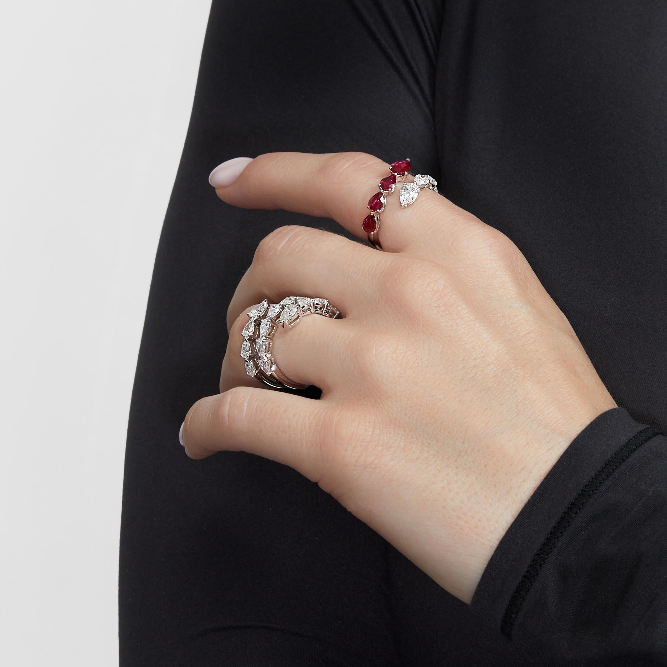 Your perfect accessory awaits in the Diamond and Ruby Bypass Ring. This chic statement piece embraces the finger with a line of pear-shaped white diamonds that faces a row of pear-shaped gemstones. The ring’s open design is fashion-forward, yet–like