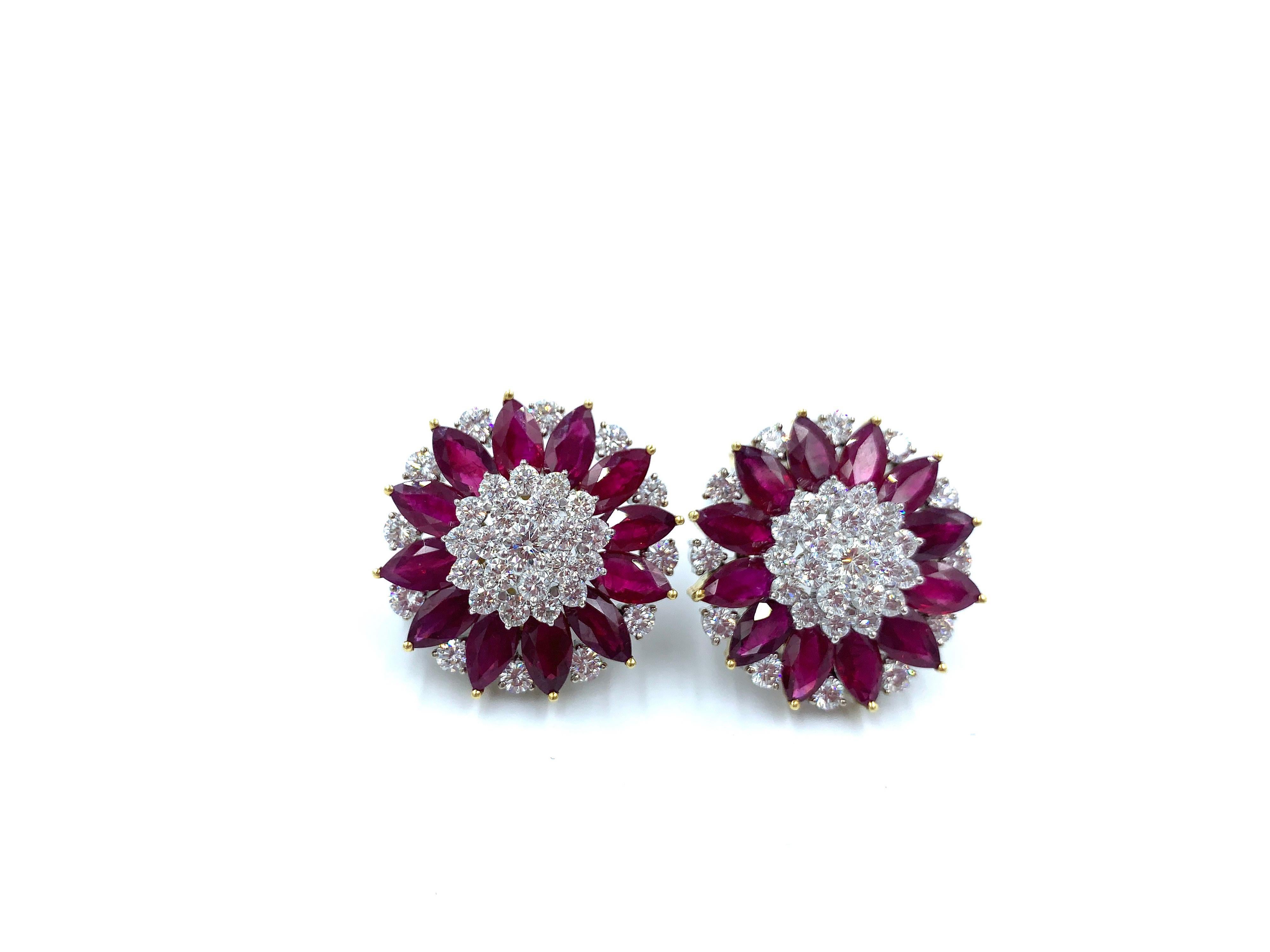 Bold and elegant earrings, shaped like pinwheels or flowers, in 18 kt white and yellow gold. Central clusters of diamonds are surrounded with vibrant red marquis shaped rubies and diamonds. There are 32 carats of rubies and 7.40 carats of diamonds