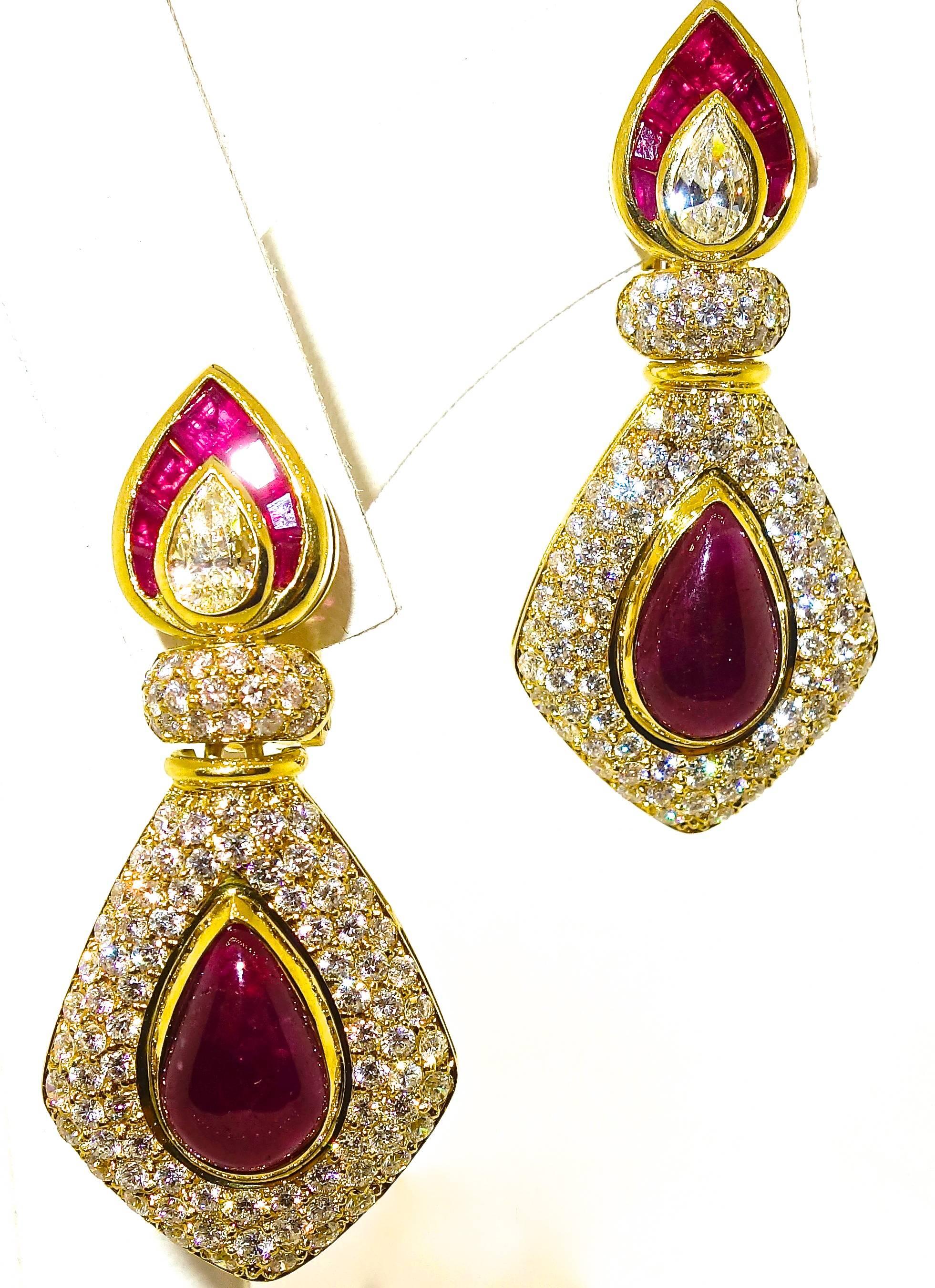 18K yellow gold pendant style earrings possessing 22 fine red rubies weighing approximately 8 cts.  These bright stones are accented with fine white pave set diamonds - all H (near colorless) and very slightly included (VS), (TW 2.75 cts).  The