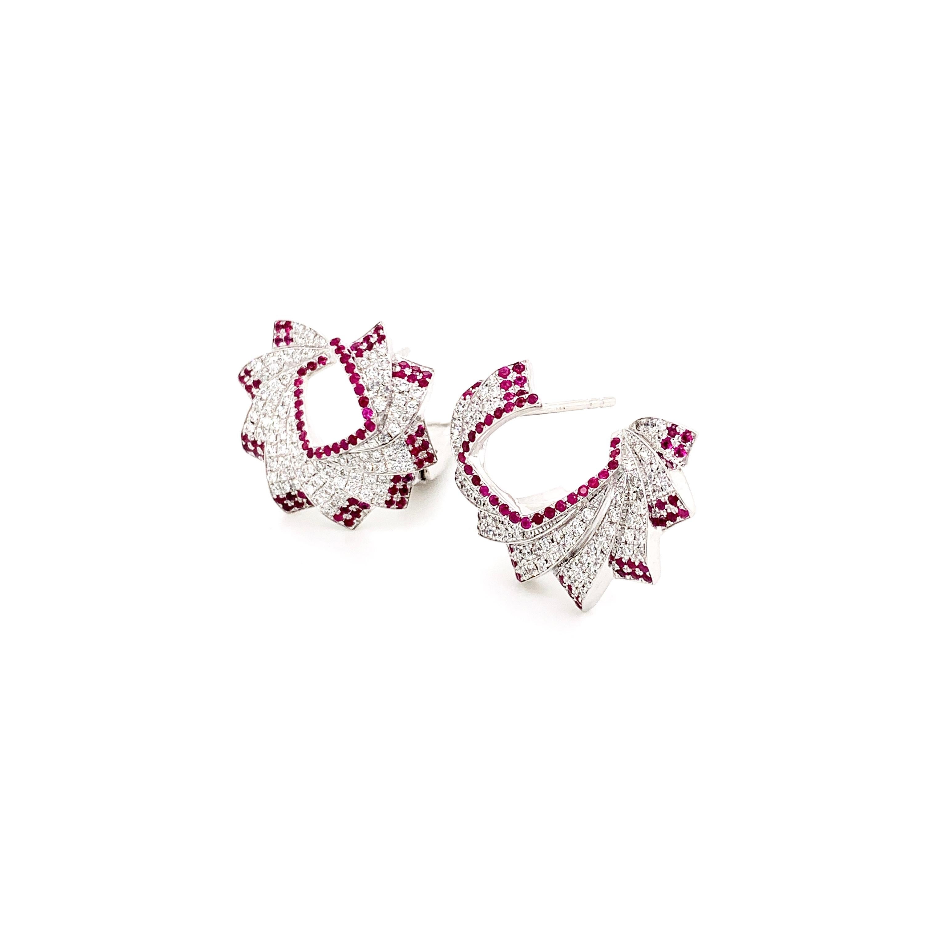 Diamonds and rubies are exquisitely set in these charming Mogra (Jasmine) flower inspired earrings.

The beautiful shade of red of the rubies border the diamond micro pavé of these earrings that sit perfectly on your ears for a magnificent