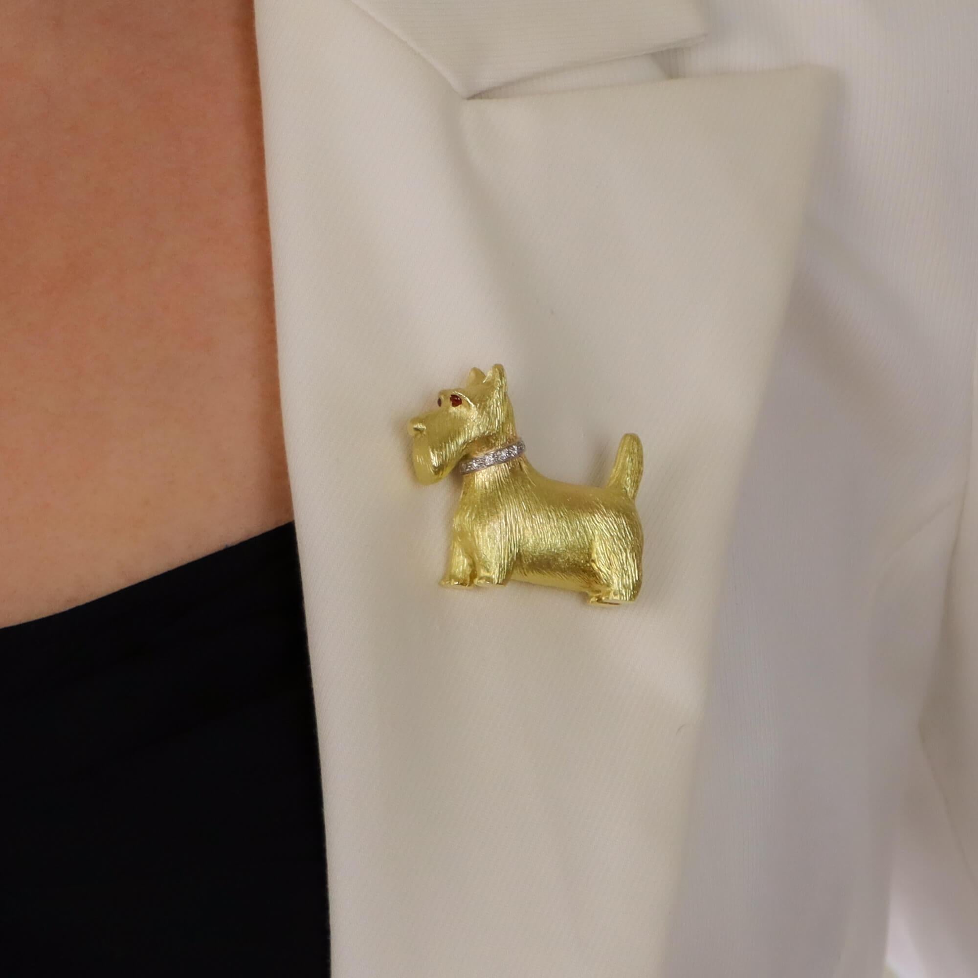 A beautiful ruby and diamond Scottish terrier dog pin brooch set in 18k yellow gold.

The brooch depicts a standing side view of Scottish terrier which is set with a pavé round brilliant cut diamond collar. The dogs fur has been beautifully hand