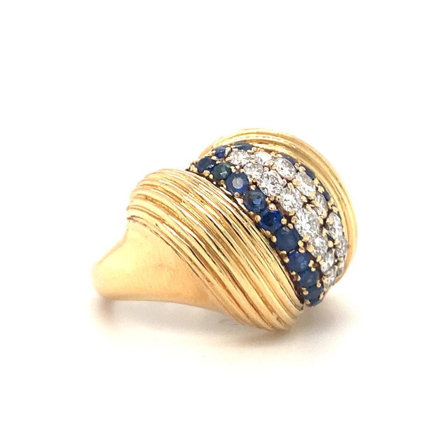 One diamond and sapphire 18K yellow gold ring featuring a ribbed gold work design, enhanced by 16 round brilliant cut diamonds totaling 0.80 ct. and 24 round brilliant cut sapphires totaling 1 ct. Circa 1960s.

Flawless, refined,
