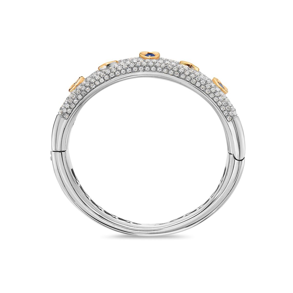This statement bangle features 8.76 carats of diamonds and 1.15 carats of sapphire set in 18K white and yellow gold. Diameter is 2 1/4 inches. 72 grams total weight. Made in  Italy. 

