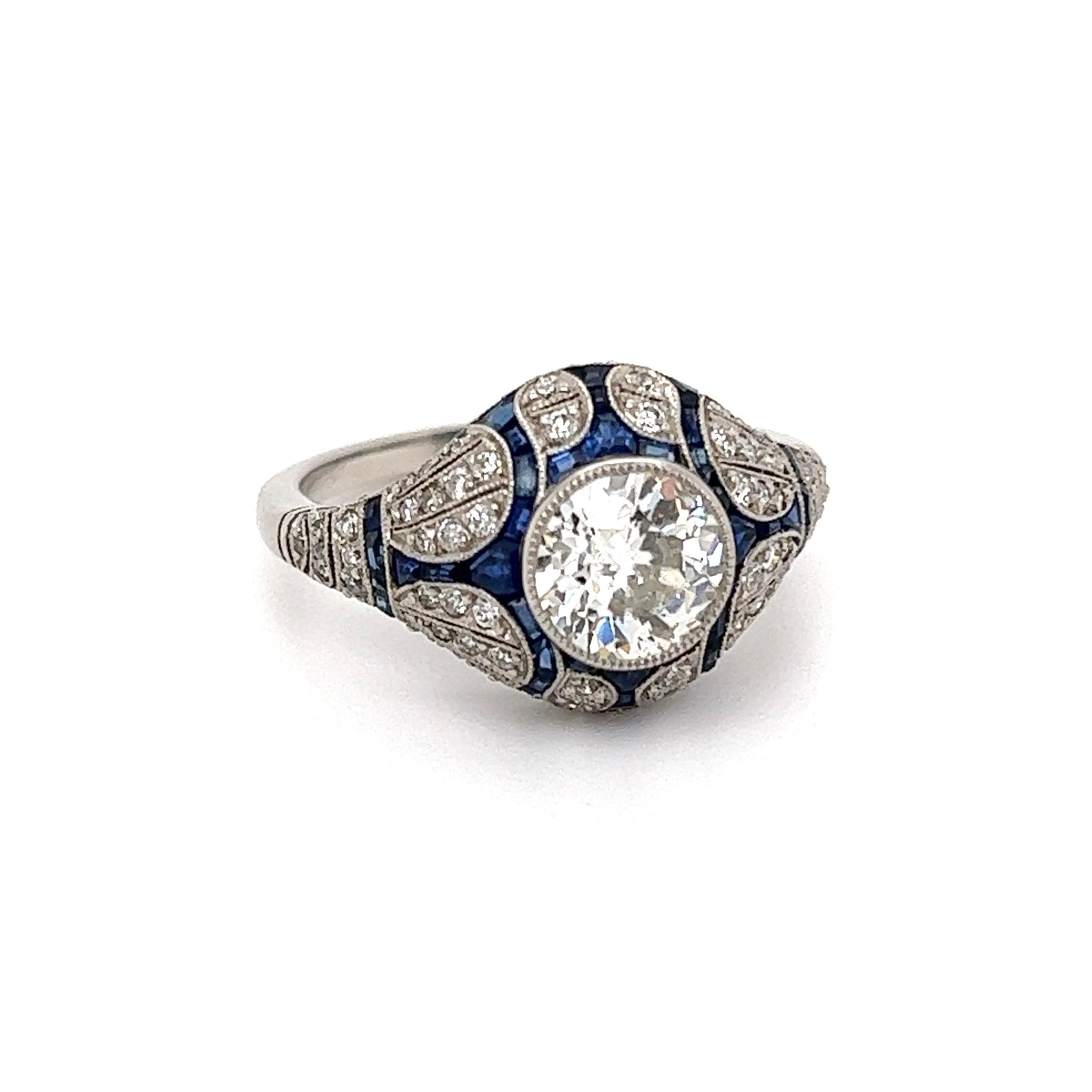 Simply Beautiful! Finely detailed Cocktail Ring, center securely Hand set with a 1.11 Carat Old European Cut Diamond, surrounded by 98 side diamonds weighing approx. 1.00tcw and accented by Sapphires weighing approx. 1.76tcw. Hand crafted Platinum