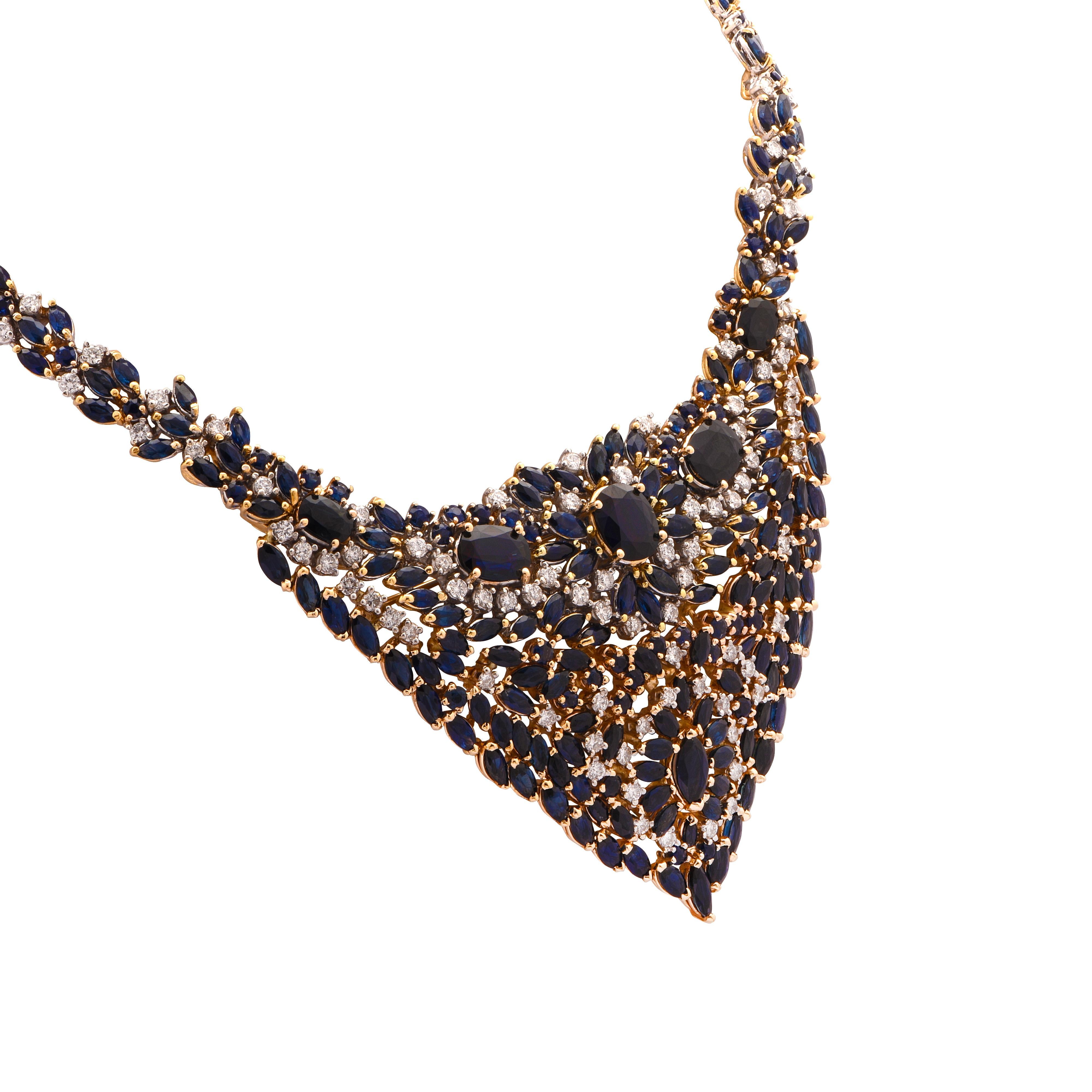 Striking Bib necklace crafted in yellow gold showcasing 87 round brilliant cut diamonds weighing approximately 5 carats total, G color, VS-SI color, and 143 mixed cut sapphires weighing approximately 25 carats total set in an eye-catching array. By