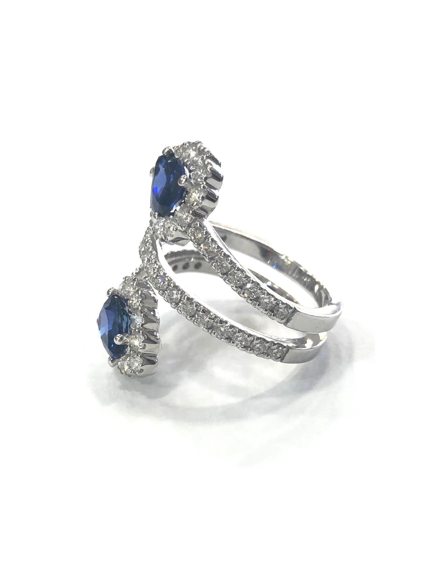 18ct White Gold Diamond and Sapphire Crossover Cocktail Ring. Set with two central pear shape natural sapphires surrounded by round brilliant cut diamonds. With Diamond set shoulders and a central band of diamonds. 
With a full english