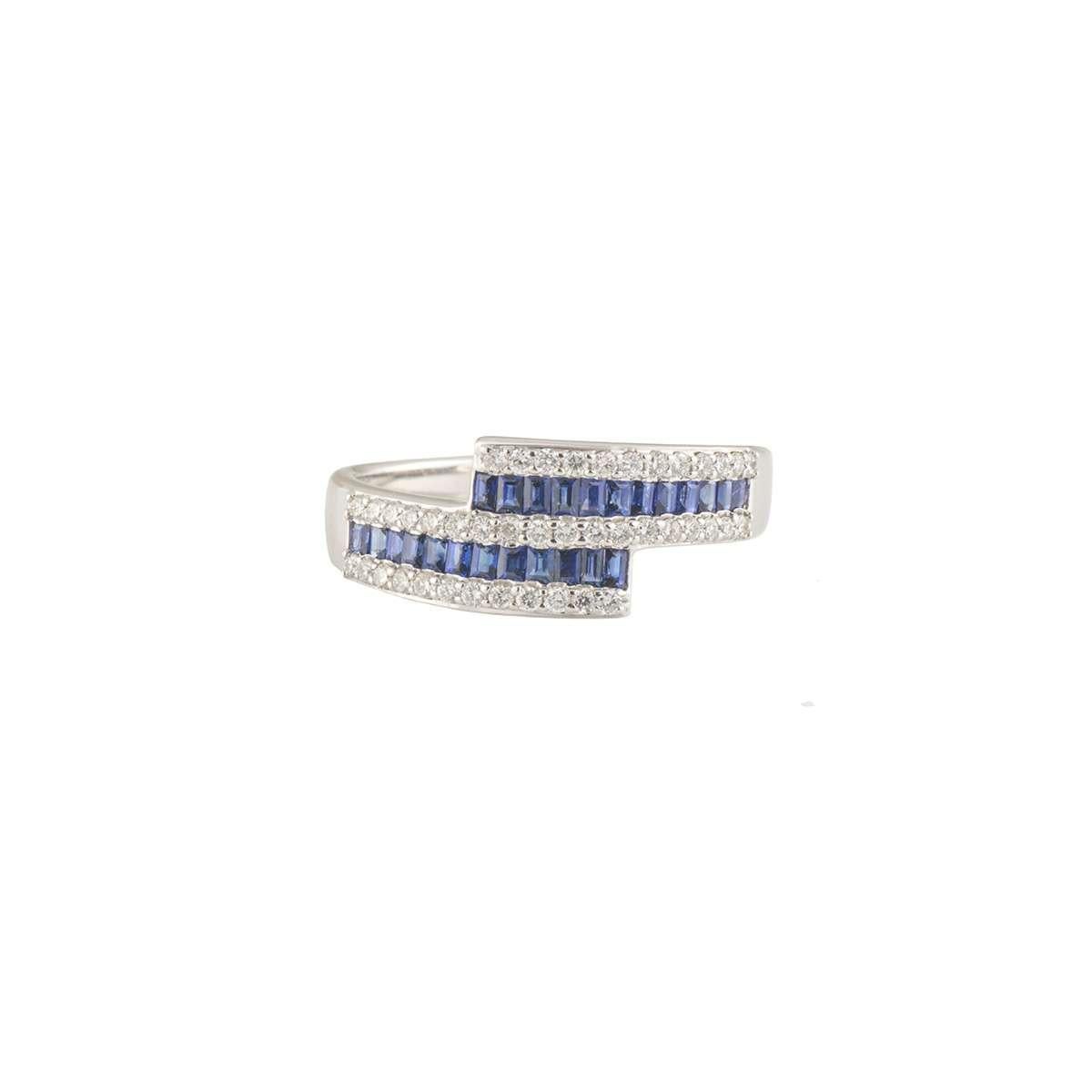 A beautiful 18k white gold diamond and sapphire crossover dress ring. The ring comprises of 3 rows of round brilliant cut diamonds alternating with 2 rows of baguette cut sapphires. The diamonds have a total weight of 0.25ct, G-H colour and VS-VVS