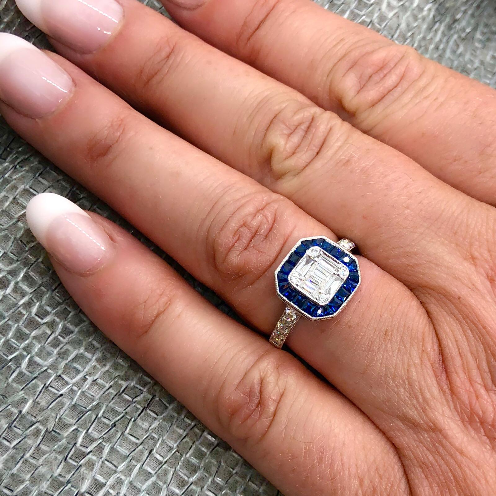 Enjoy the elegance of the deco era with this 18k white gold ring. Set with baguette and round brilliant-cut diamonds, framed with an octagonal halo of square-cut sapphires, the ring has a low profile perfect for everyday wear. The total diamond