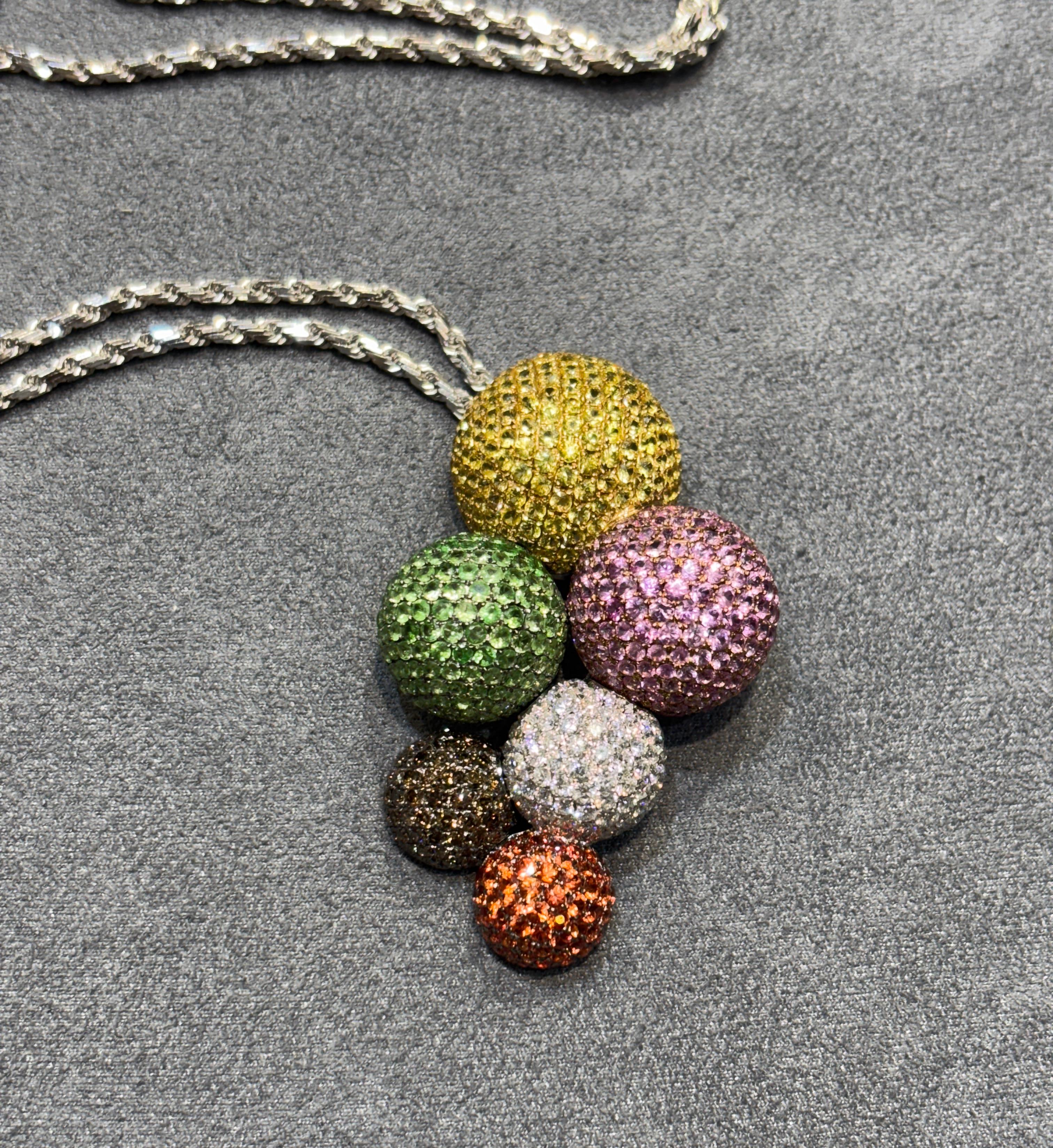 Questo delizioso pendente a forma di grappolo di bolle è composto da 5,70 carati esatti di diamanti bianchi e neri e 10,60 carati di zaffiri colorati. I pesi sono incisi sul retro del ciondolo. Il ciondolo fa parte di un set con un anello