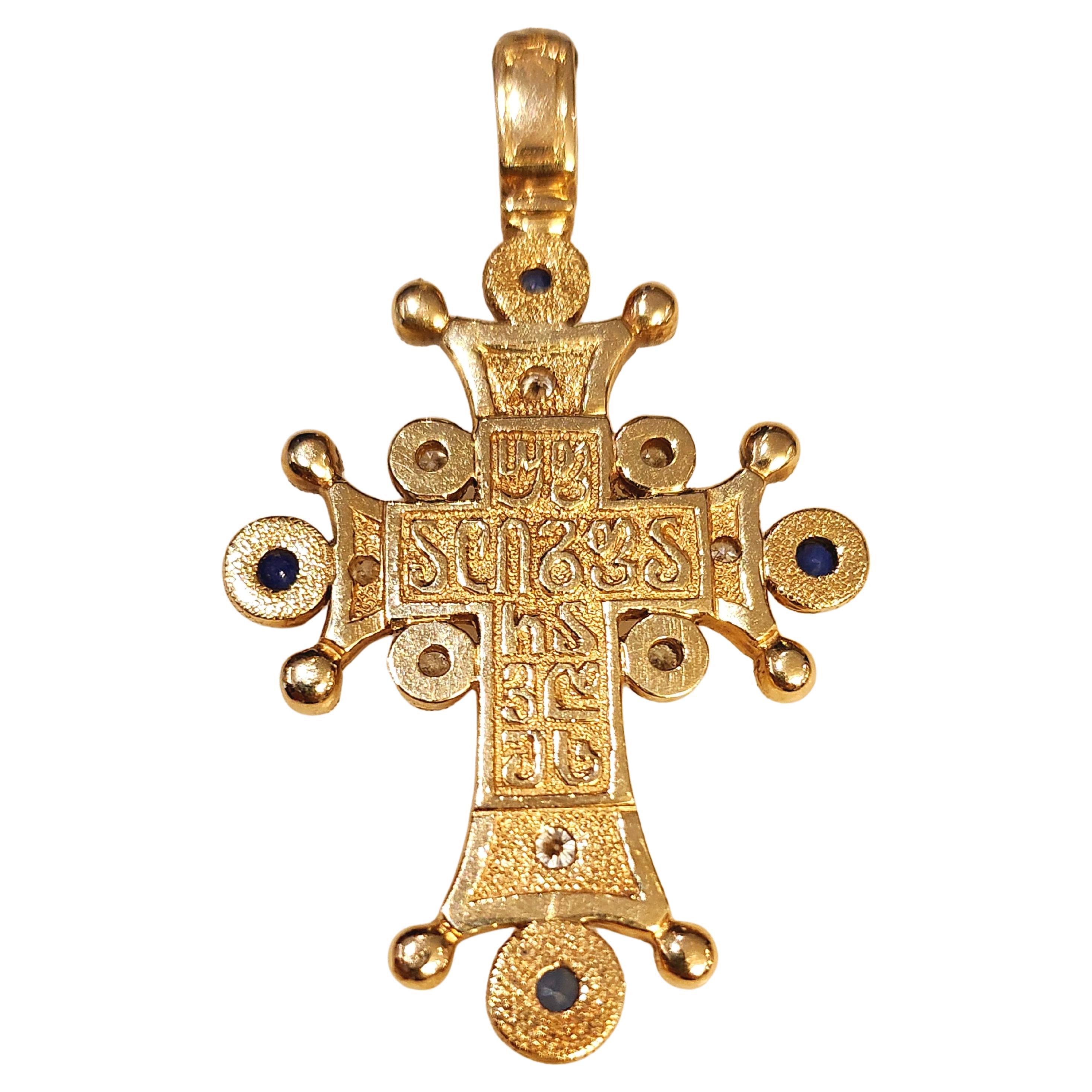 Grand pendentif croix en or 14k finement fait à la main flanqué de diamants taille brillant de 0.90 carats et de saphirs bleus naturels avec un travail détaillé gravé au dos. Le poids total de la croix est de 15 grammes et sa longueur est de 5cm.