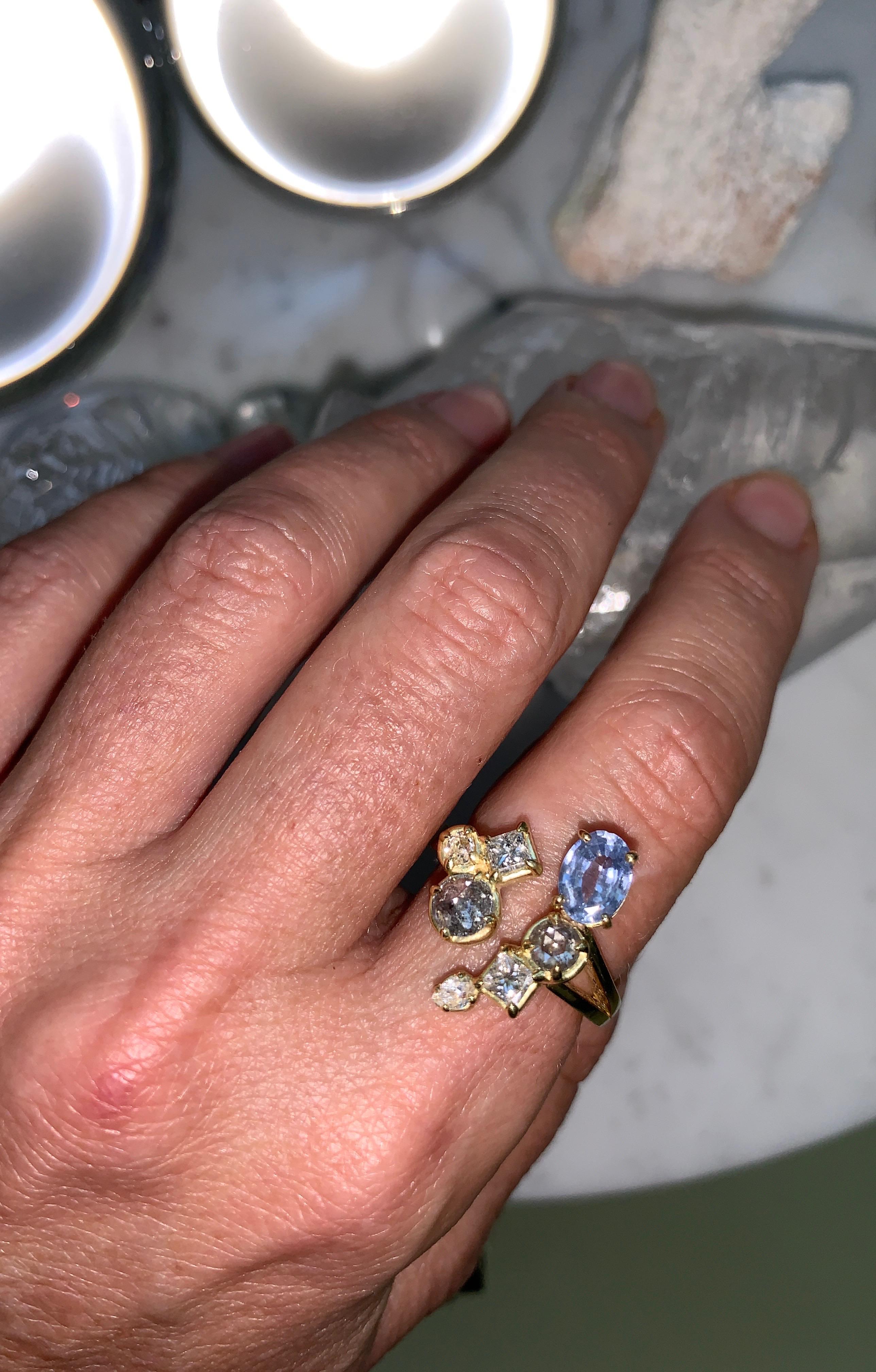 This solid 18 Karat Yellow Gold Ring is made by hand in Los Angeles, CA. It has a large oval Ceylon Blue Sapphire, White, and Grey Diamonds in different shapes. 
This Ring is one of a kind and made by hand using recycled Gold and conflict-free