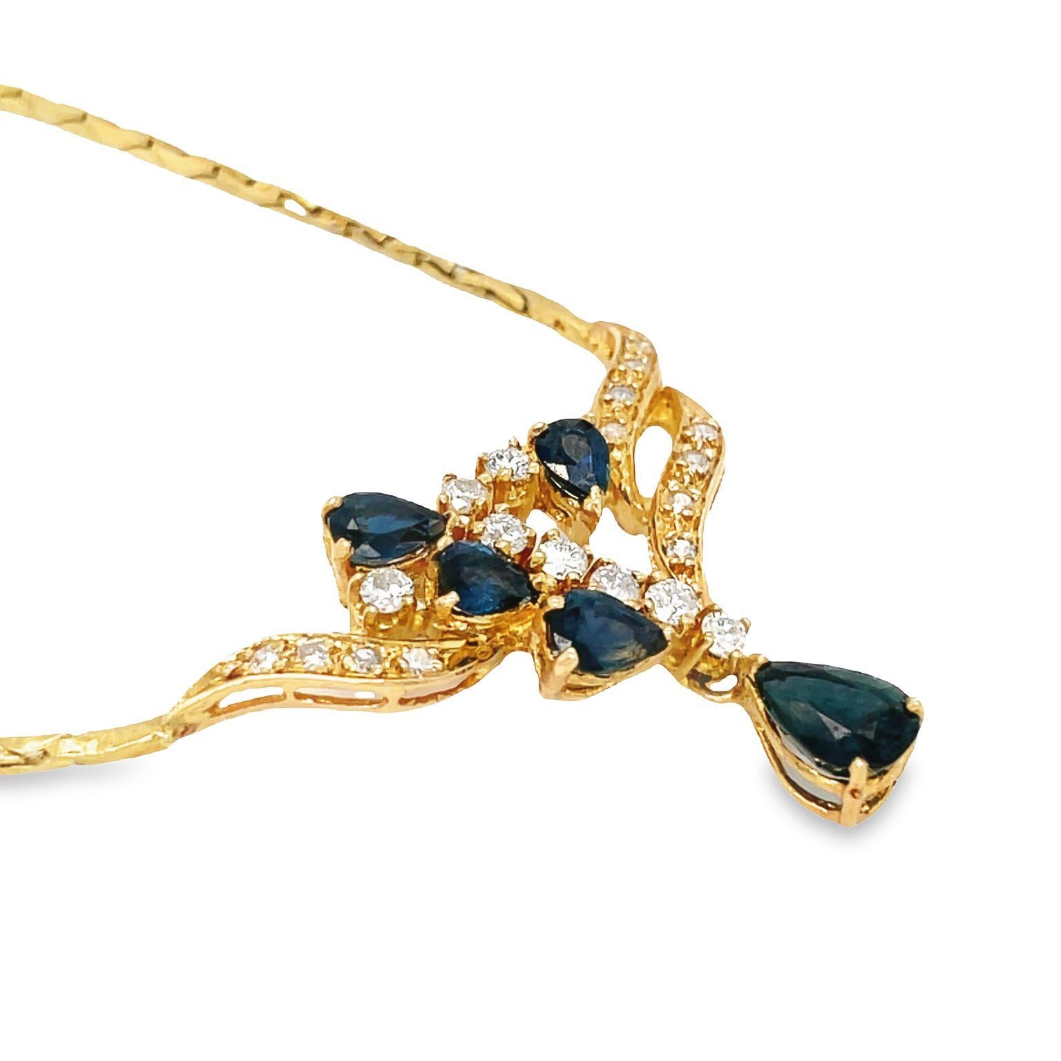 Cet élégant et séduisant collier en or jaune 18 carats présente un ravissant motif composé de cinq saphirs bleus en forme de poire et de vingt diamants taille brillant. Le saphir central mesure environ 7,5 mm, entouré de quatre saphirs plus petits