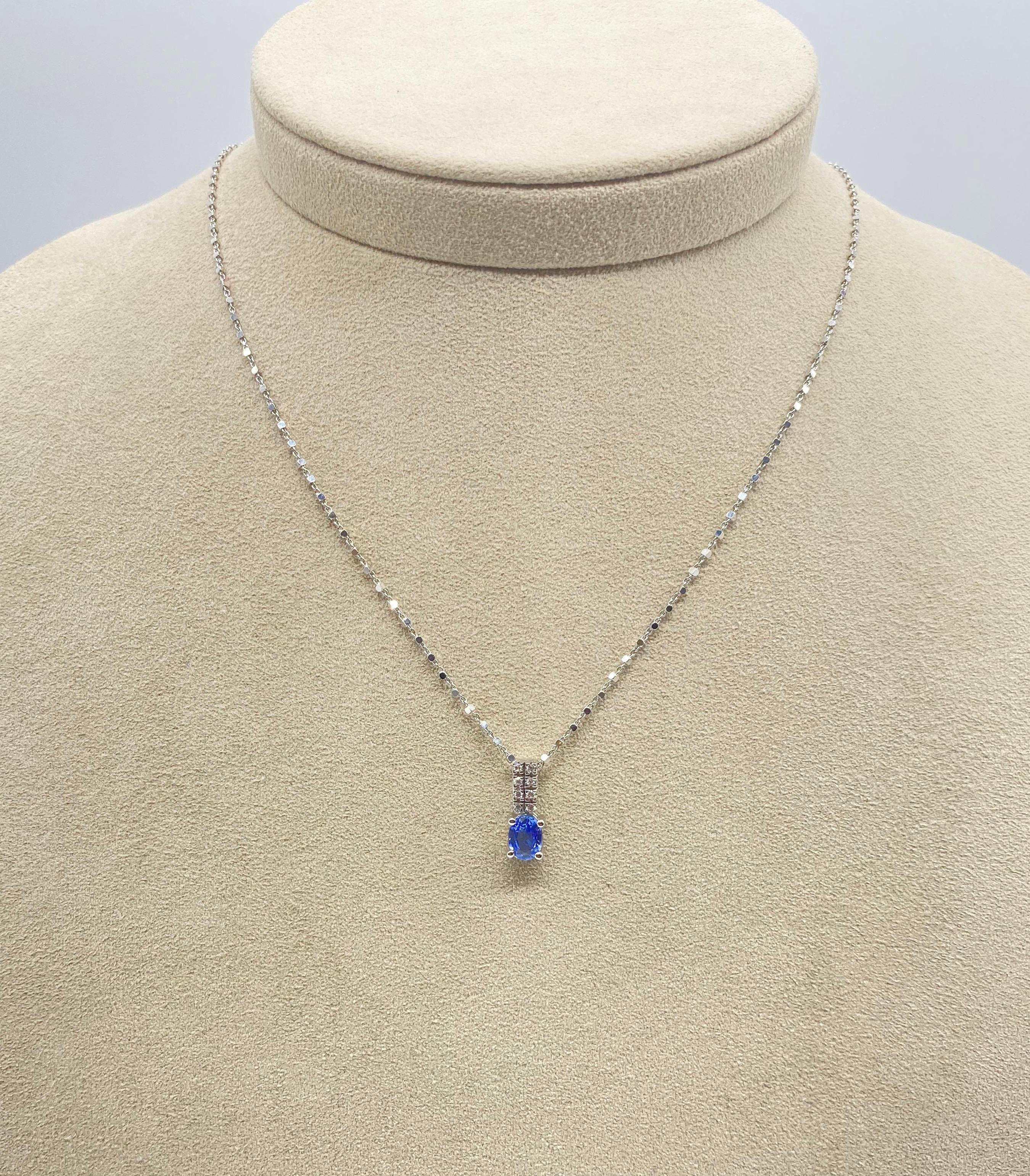 Entdecken Sie dieses wunderbare Collier aus 18-karätigem Weiß, das mit funkelnden Diamanten und einem ovalen blauen Saphir verziert ist und eine perfekte Kombination aus Schönheit und Eleganz bietet. Das Collier ist mit einem originellen Mailing