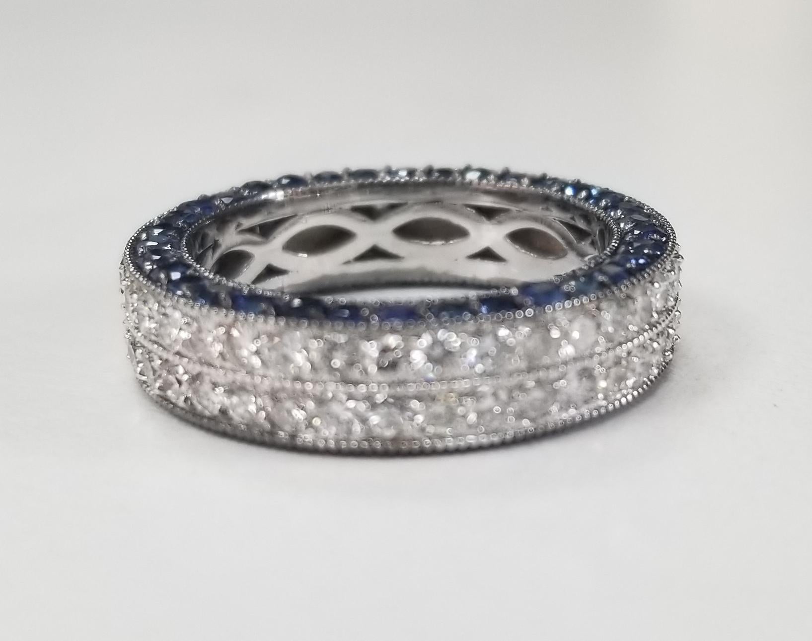14k white gold ladies 2 row diamond pave eternity ring with sapphires pave in the side of the ring, containing 76 round full cut diamonds of very fine quality weighing 1.65cts. and 68 round blue sapphires weighing 2.15cts. ring size is 6.25, a new