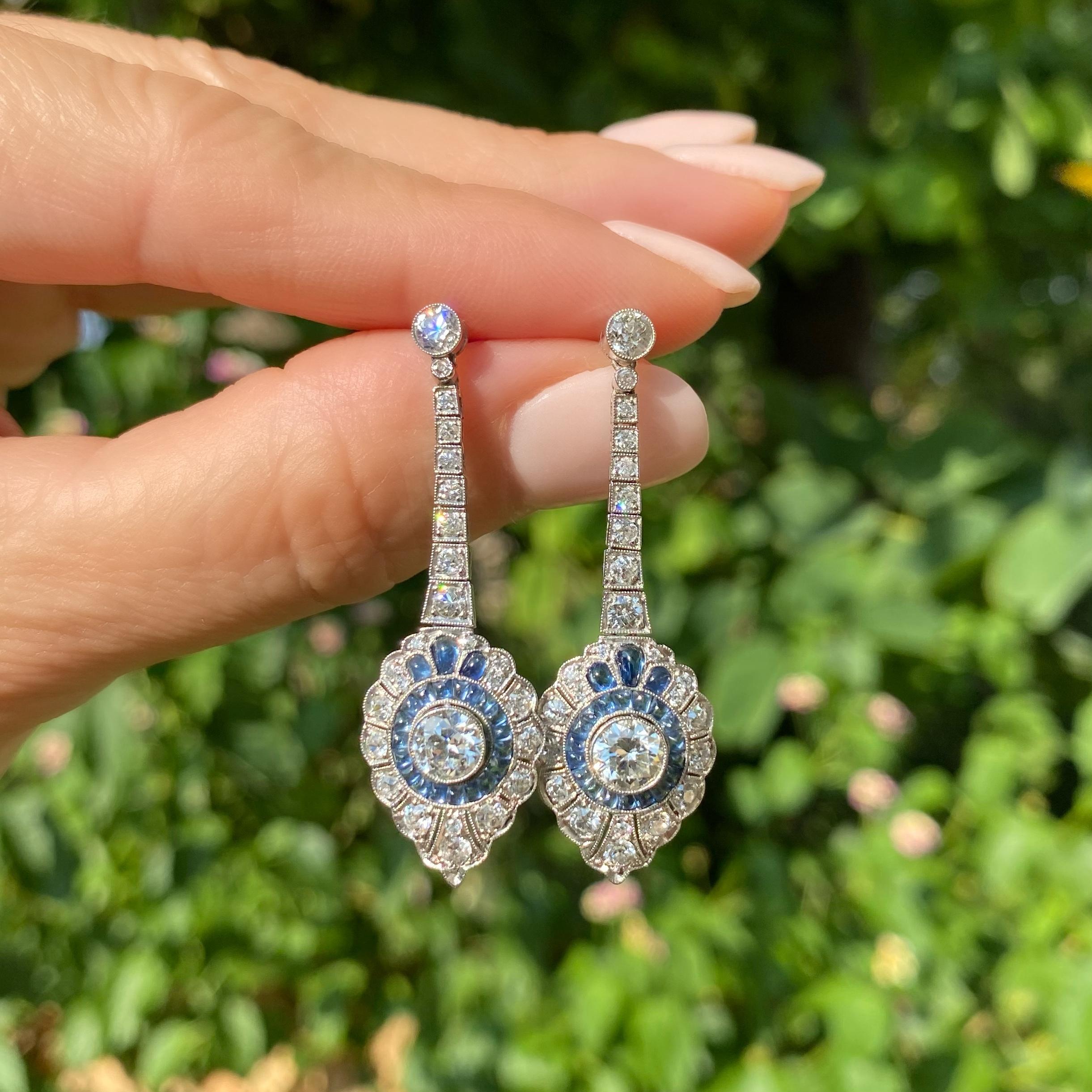 Simply Beautiful! Finely Detailed Art Deco Style Diamond and Blue Sapphire Chandelier Drop Earrings. Hand crafted in Platinum and Hand set with 2 round diamonds, approx. 1.10tcw, 42 Buff top Blue Sapphires, approx. 2.10tcw and 50 diamonds, approx.