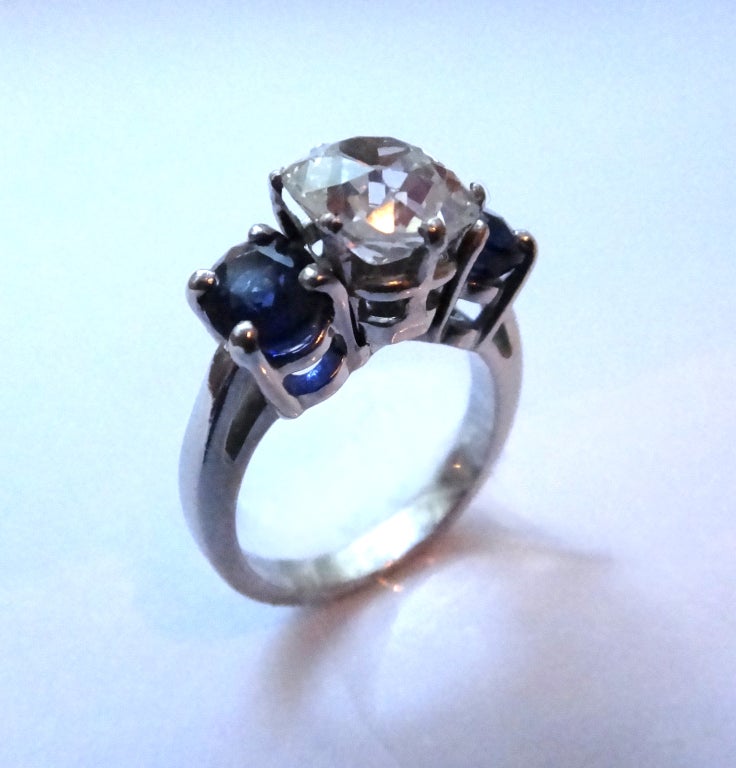 Set with old-mine-cut diamond weighing 2,13 carats, clarity SI1, color I. 2 sapphires weighing ca. 1,10 carats. 
Mounted in platinum. Weight 7,23 g. Ring size: 49 ( US 4 3/4 ) Resizable