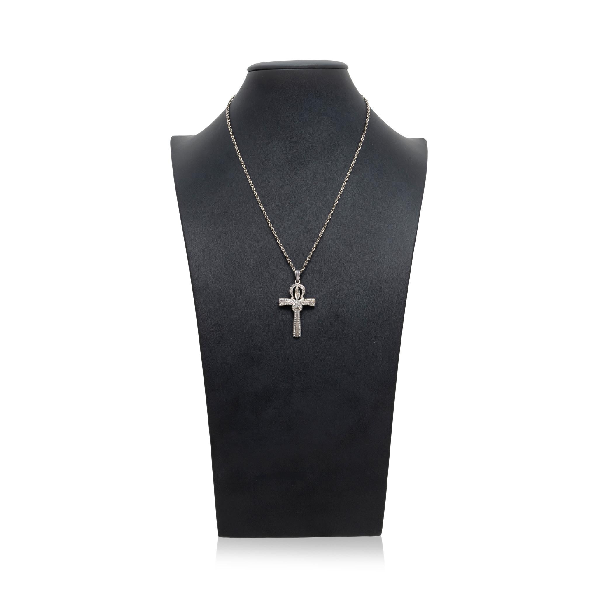 Kreuz-Anhänger mit Diamanten und Silber. Mit verknotetem Anubis-Stil Design mit insgesamt 82 kleinen runden Diamanten entlang der Oberfläche mit einem Gewicht von ca. 79cttw. Die Mitte des Knotens ist mit einem geätzten Blattmuster versehen. Mit