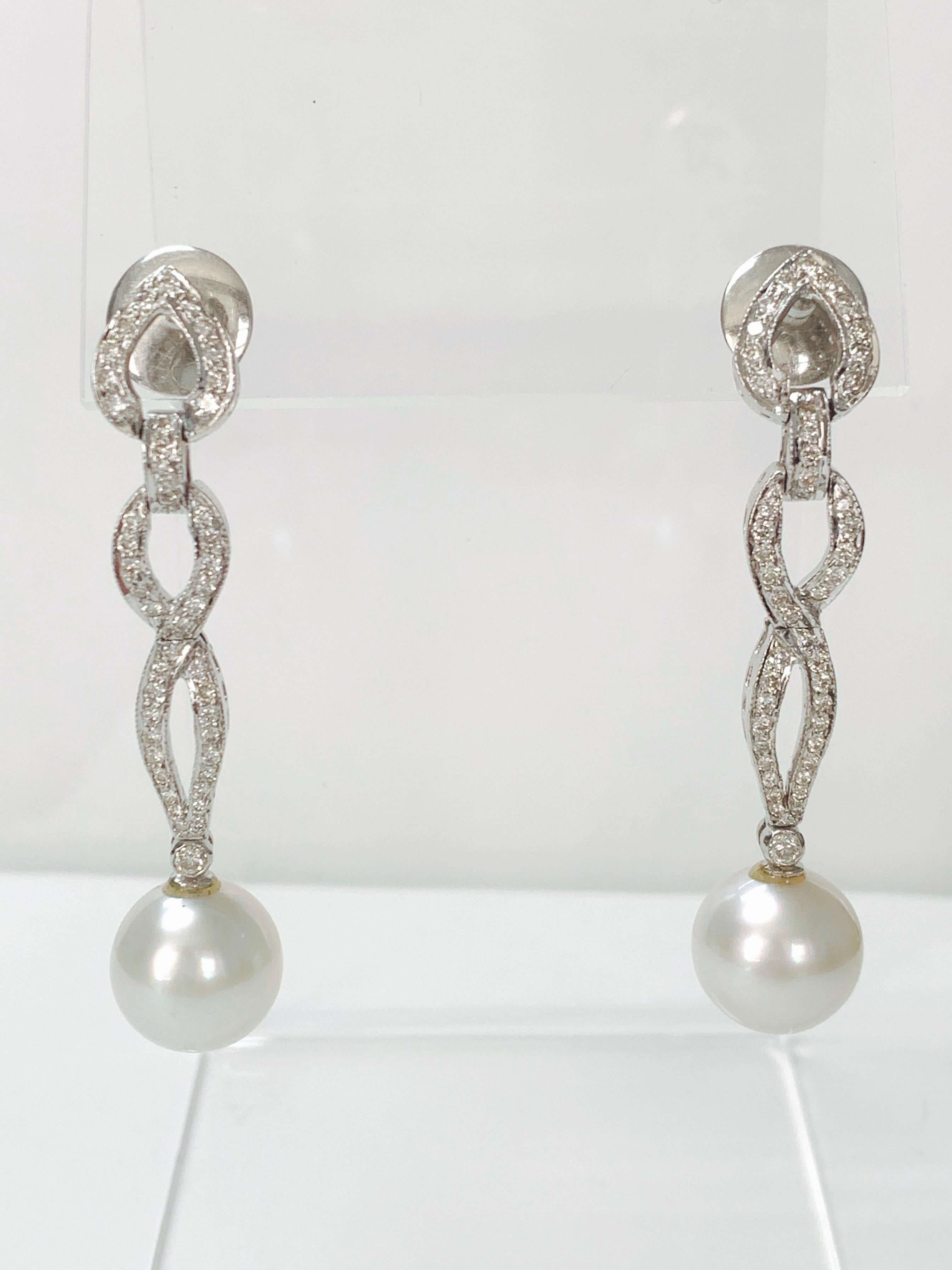 Very classy diamond and south sea pearl earrings in 18k white gold. 
The details are as follows : 
Diamond weight : 1.15 carat ( GH color and VS clarity) 
South sea pearls : 11mm each 
Measurements : 2 inches long 
Metal : 18k white gold 