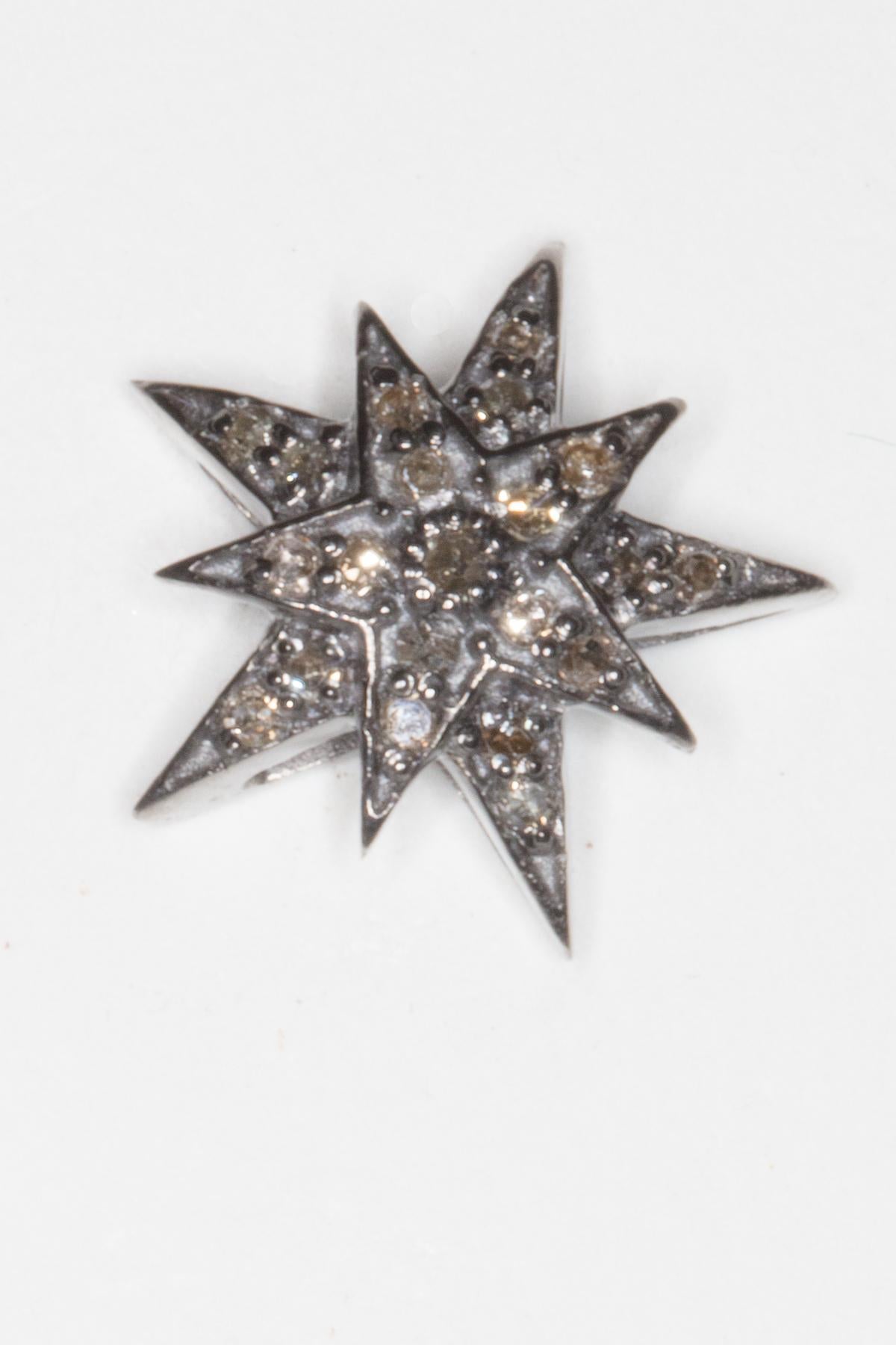 A pair of pave`-set diamond stud earrings in a dimensional star motif.    Oxidized sterling silver and 18k gold post for pierced ears.  Diamond weight is .36 carats.

