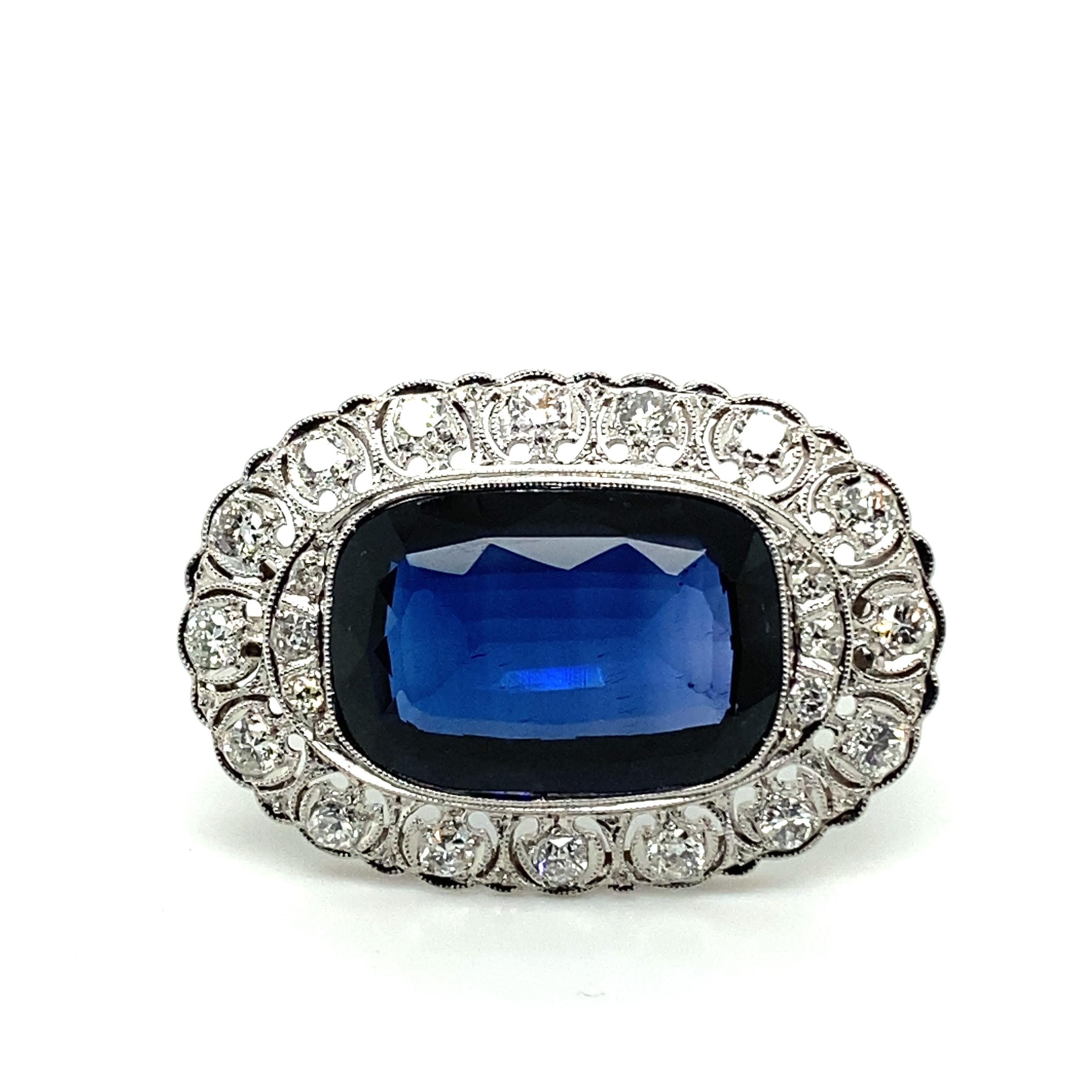 This elegant brooch is inspired by the finely crafted jewellery of the Edwardian era. This handmade brooch is handcrafted in 14 karat white gold and set with a cushion-shaped synthetic sapphire of approximately 11.00 carats.
The entourage is set