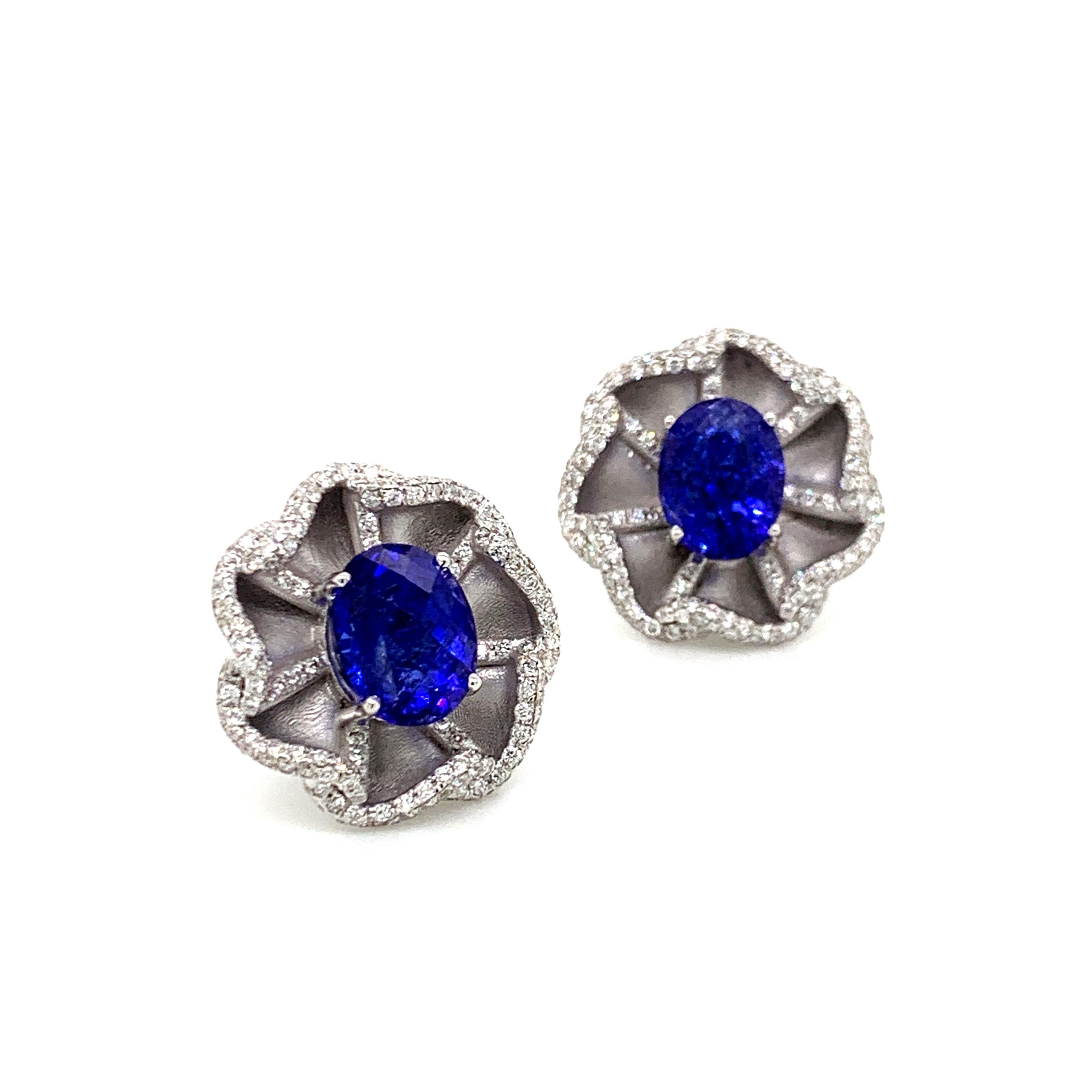 These beautiful diamond stud earrings with deep blue tanzanite ovals are set in textured 18 karat white gold. An elegant and classic look.

•	Total Diamond Weight: 1.09 carats
•	Tanzanite Weight: 5.97 carats
•	Diamond Quality/Colour: VS/FG (Clean,