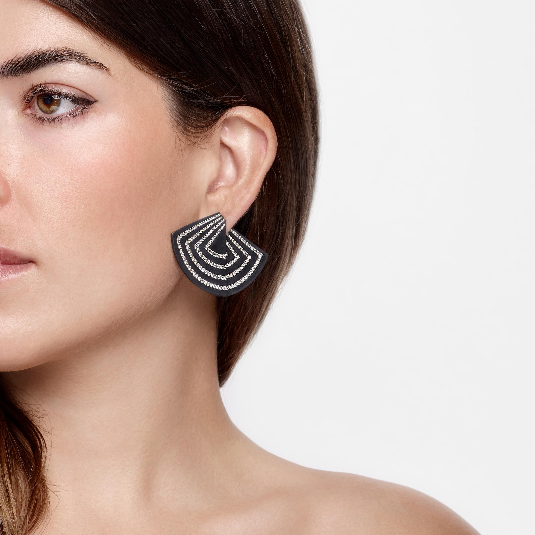 These unique diamond and titanium earrings are a stunning addition to any high jewelry collection. The combination of titanium and diamonds lends these earrings a distinctly modern look. Their fan shape is designed to catch the light beautifully