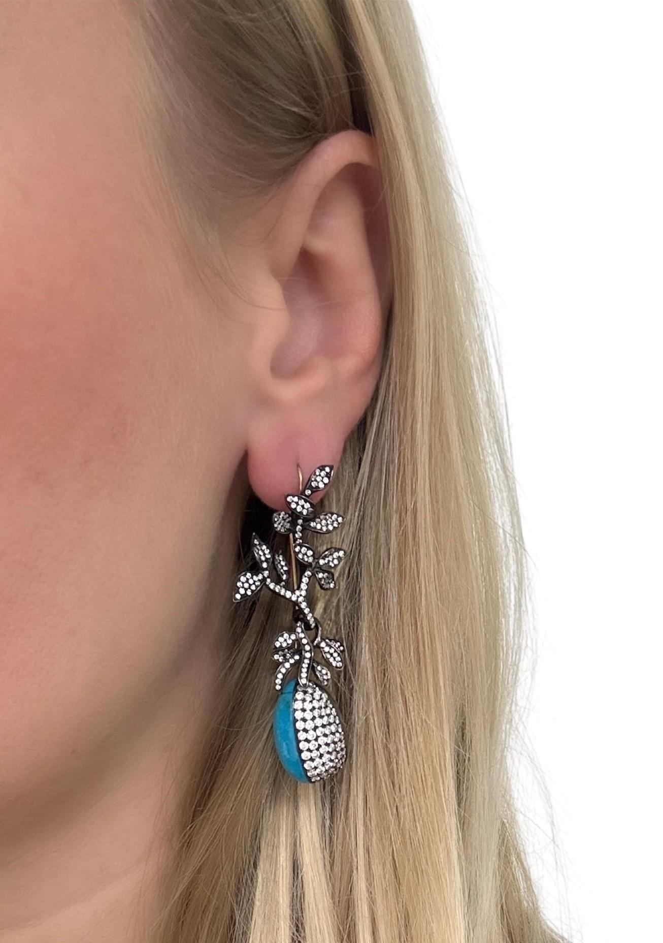 These gorgeous drop earrings featuring a branch design suspending two pear cabochon turquoise and numerous round brilliant cut diamonds weighing approximately 3.75 carats total. Crafted out of 14 karat blackened gold, these beautifully made earrings
