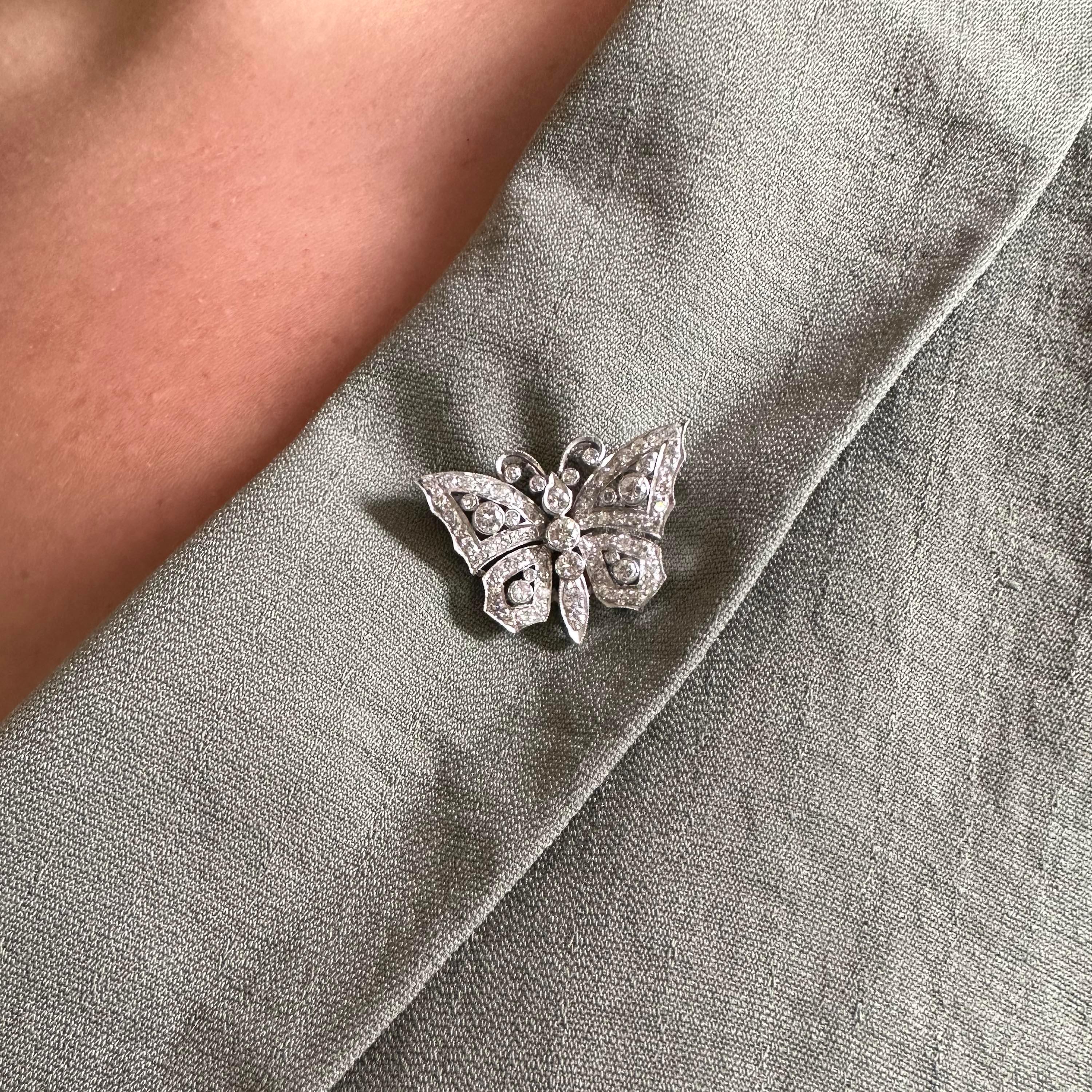 A diamond butterfly brooch, set with round brilliant-cut diamonds in rub over and grain settings, mounted in platinum, with a pin and roller catch fitting, circa 1990, with and approximate total diamond weight of 1.40 carats.