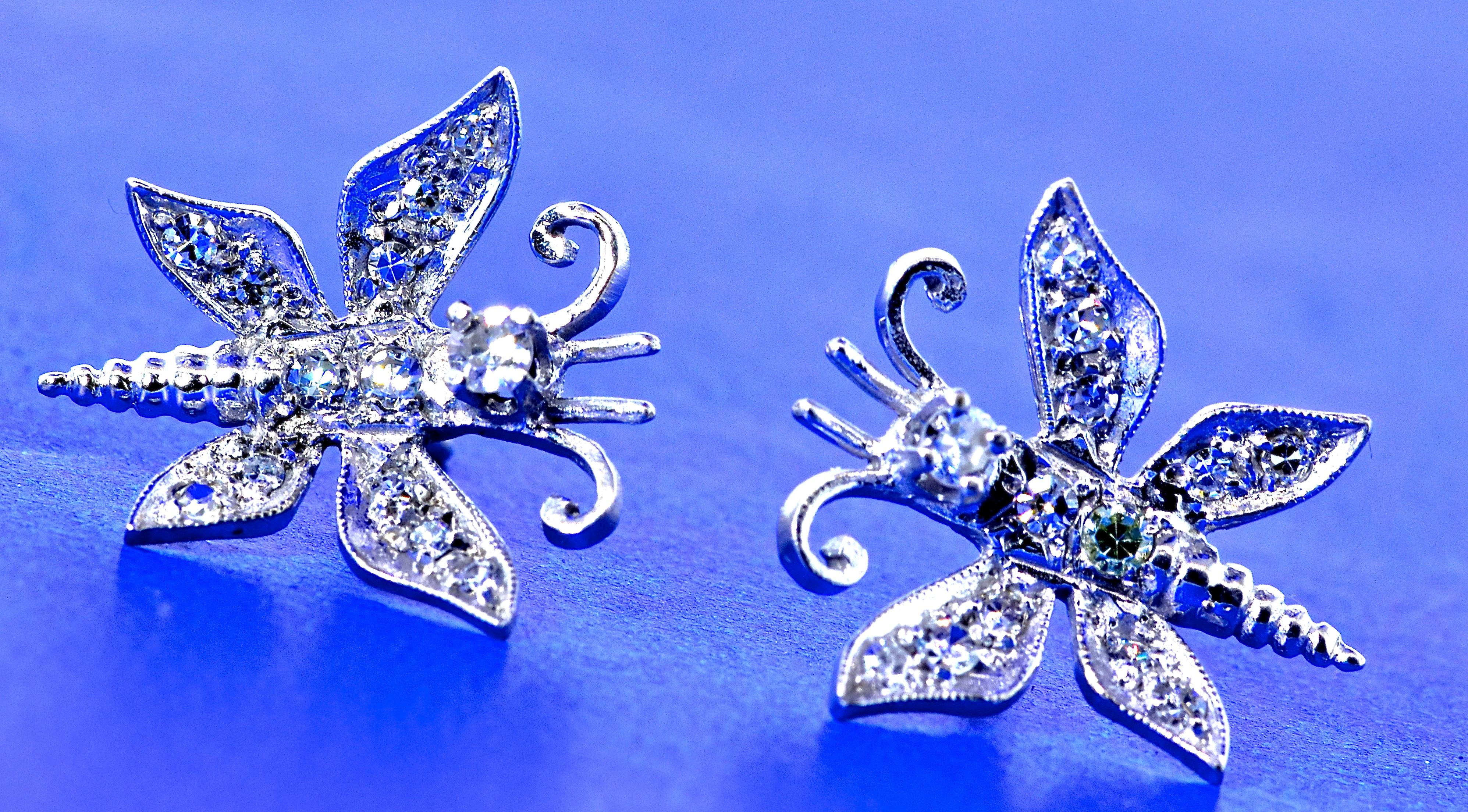 Diamond and white gold butterfly motif stud type contemporary  earrings.  The modern brilliant cut diamonds are bead set into the white gold creating a whimsical butterfly stud earring.  The 26 diamonds are estimated to be all near colorless, H, and
