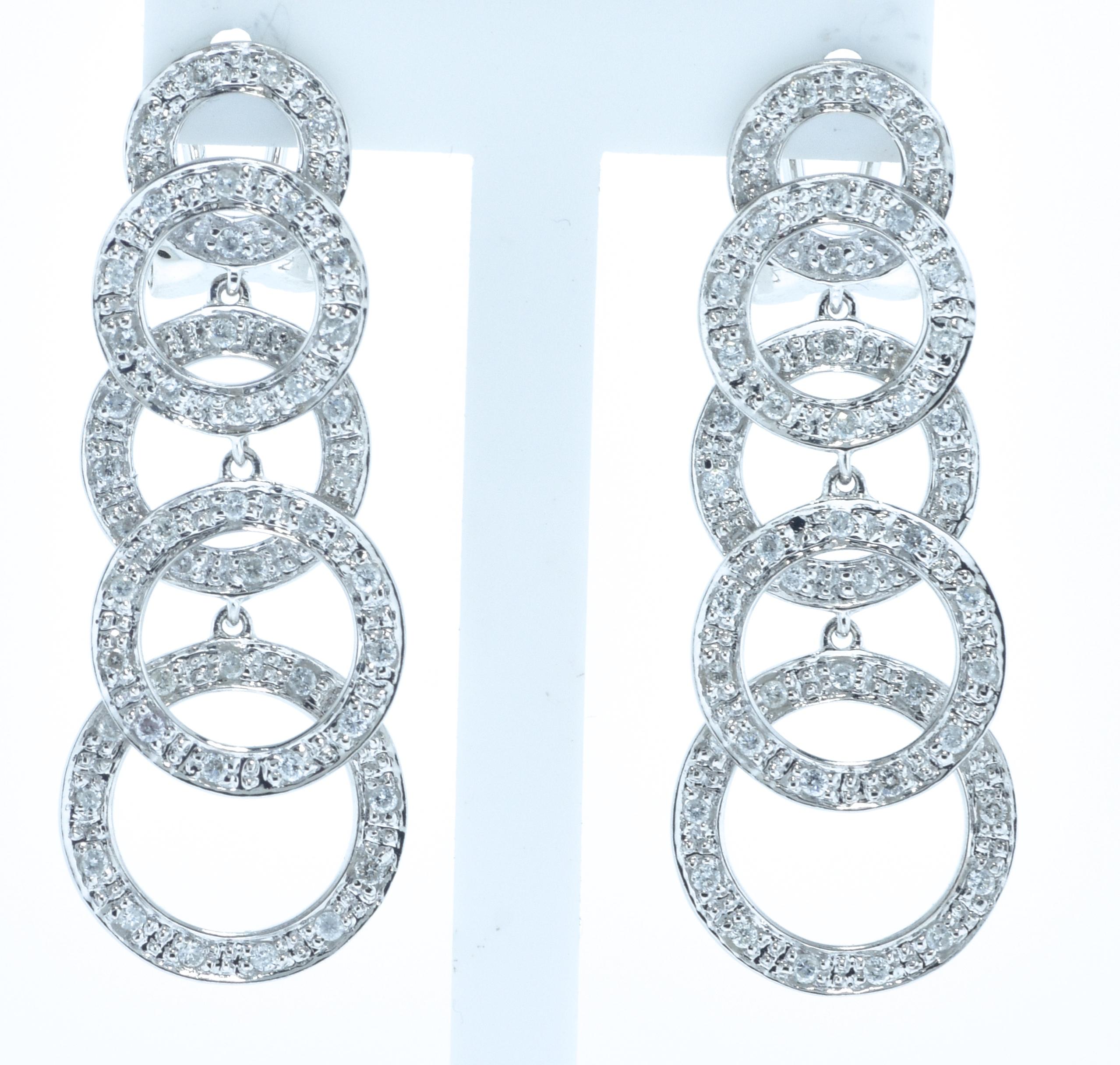  White gold dangling spheres studded with small round brilliant cut white diamonds.  There are 104 well matched diamonds amounting to approximately 1 ct.  These earrings have wonderful movement, they are 1.25 inches in length.  Distinctive and easy