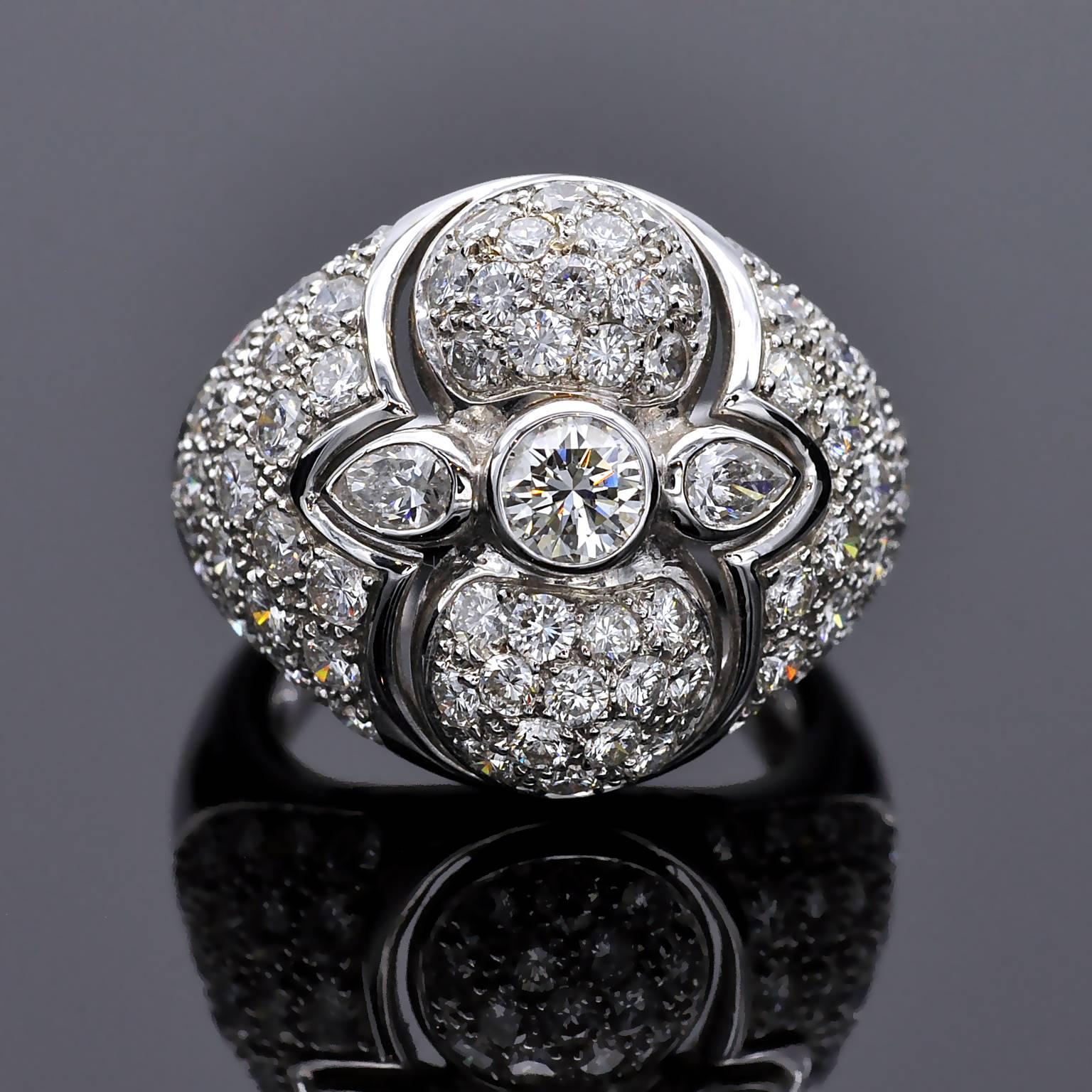 Bague de cocktail exquise en diamant bombé. Au centre d'un gracieux motif, un diamant rond de taille brillant et deux diamants en forme de poire sont sertis en chaton tandis que le reste de la bague est généreusement...  serti .
Détails :
Diamants