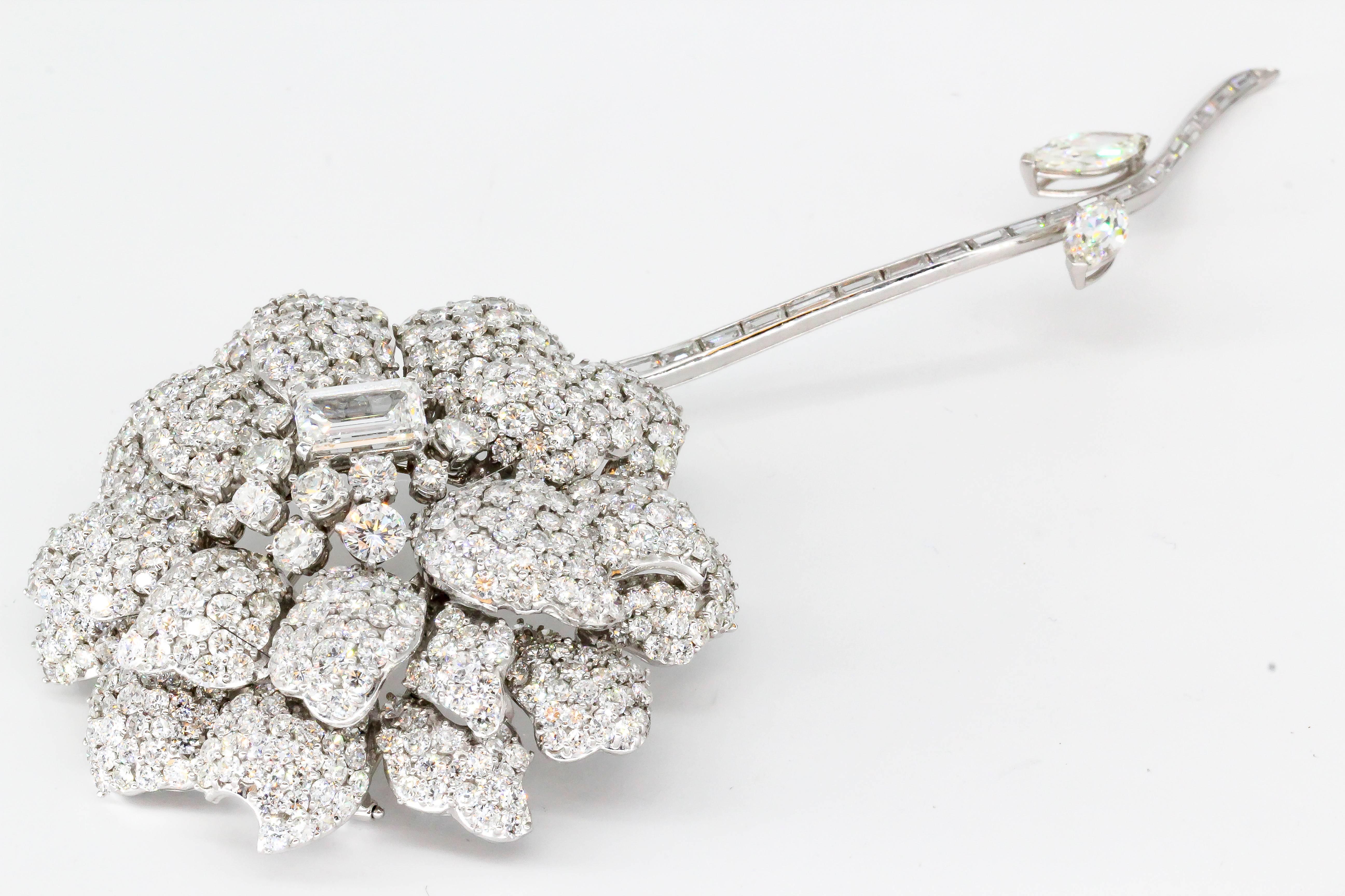 Impressive diamond and 18K white gold flower brooch with separating stem. It features approx. 40cts of high grade round brilliant cut diamonds, with approx 2.5cts emerald cut diamond as the center stone. The stem has baguette cut and marquise cut