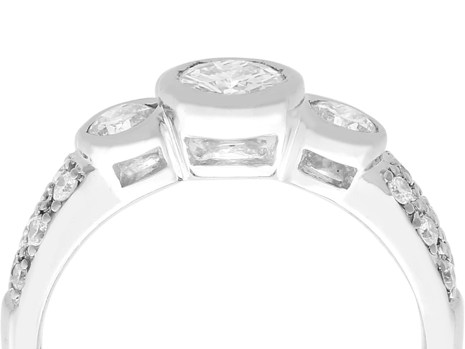 A fine vintage 0.95 carat diamond 18 karat white gold three stone/trilogy ring; part of our diverse diamond jewelry/jewelry collection.

This fine vintage diamond ring has been crafted in 18k white gold.

The feature 0.36Ct bezel set modern