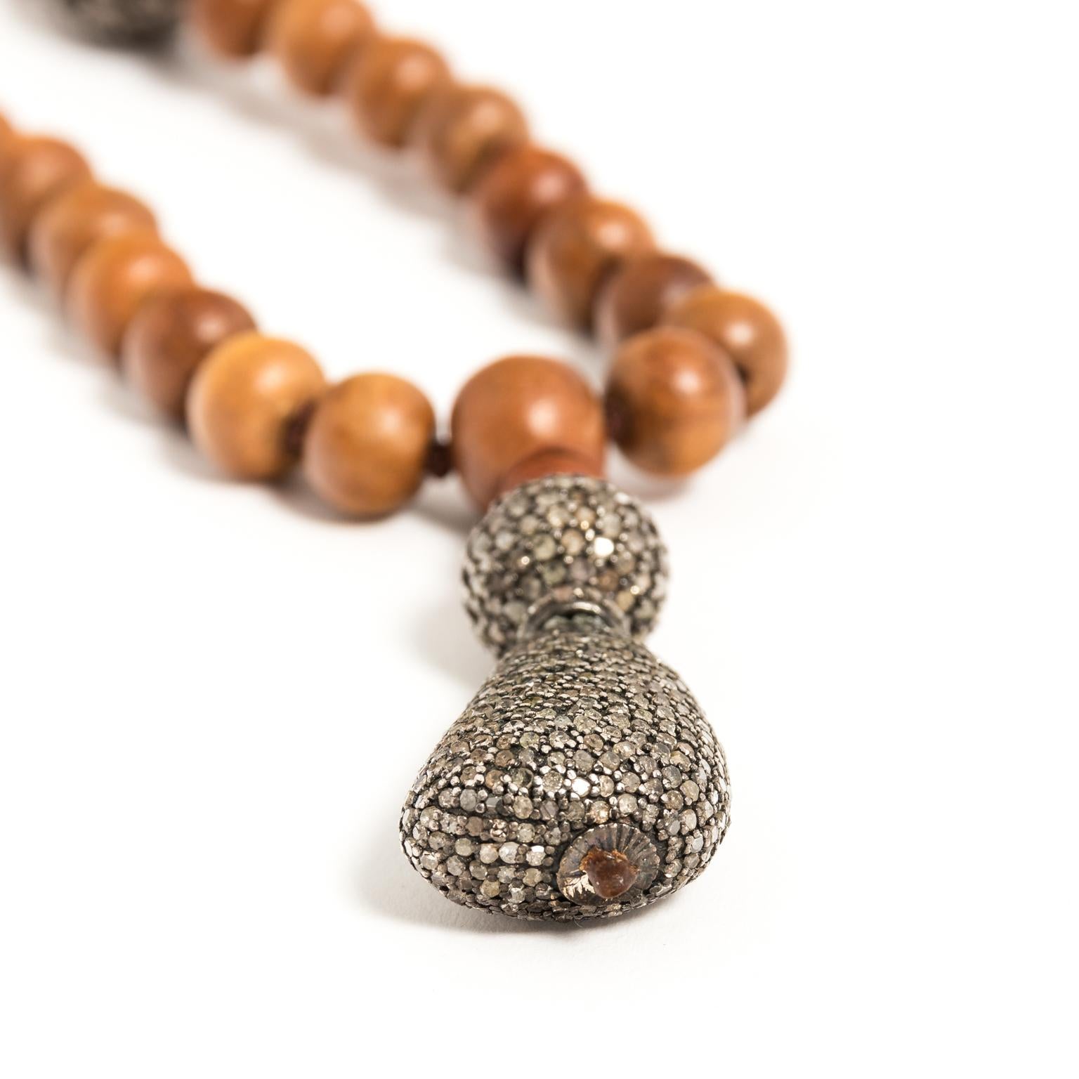 Circa 1990s sandalwood beaded necklace with two open work design elements in pave rose cut diamonds and a pendant covered in rose cut diamonds. All hand knotted with a chain that can be doubled or shortened in length.
