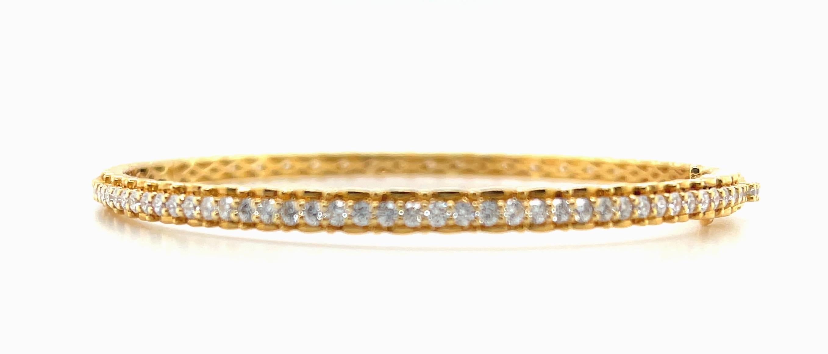 This beautiful 18k yellow gold bangle bracelet is set with exactly 100 round brilliant-cut diamonds weighing 2.63 carats total! The center row of diamonds raised against high karat gold scalloped borders, giving this gorgeous bracelet extra